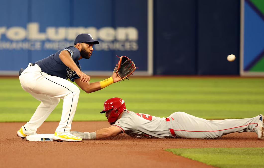 Los Angeles Angels outfielder Mike Trout (27) steals second base as Tampa Bay Rays outfielder Amed Rosario (10) attempts to tag him out during the first inning at Tropicana Field in St. Petersburg, Florida, April 16, 2024.