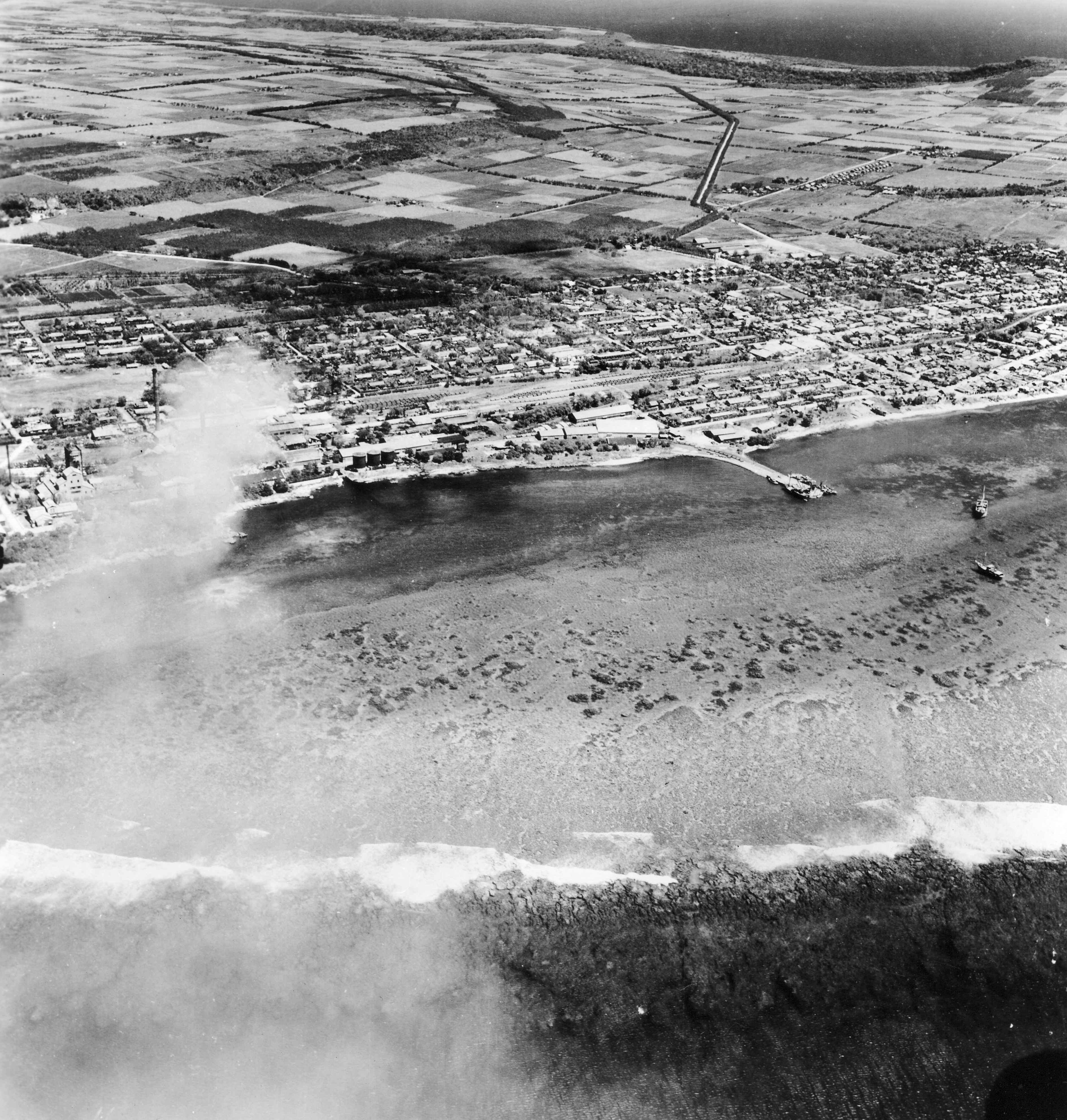 The first bomb hits West Tinian town.