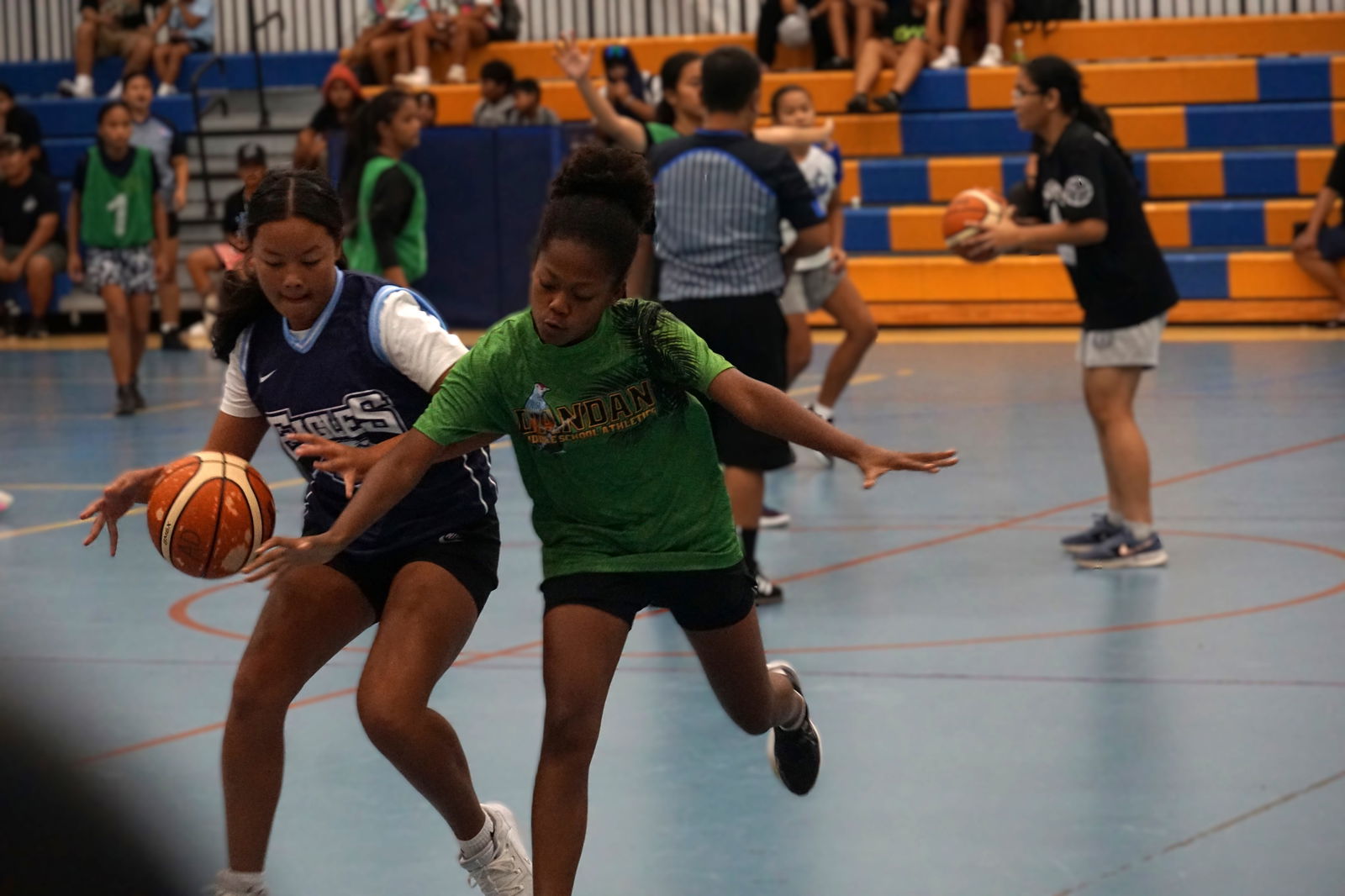 Dandan Middle School and Mount Carmel School players chase after the loose ball during a girls middle school division game of the IT&E Interscholastic Basketball League SY23-24 at the Marianas High School gym.