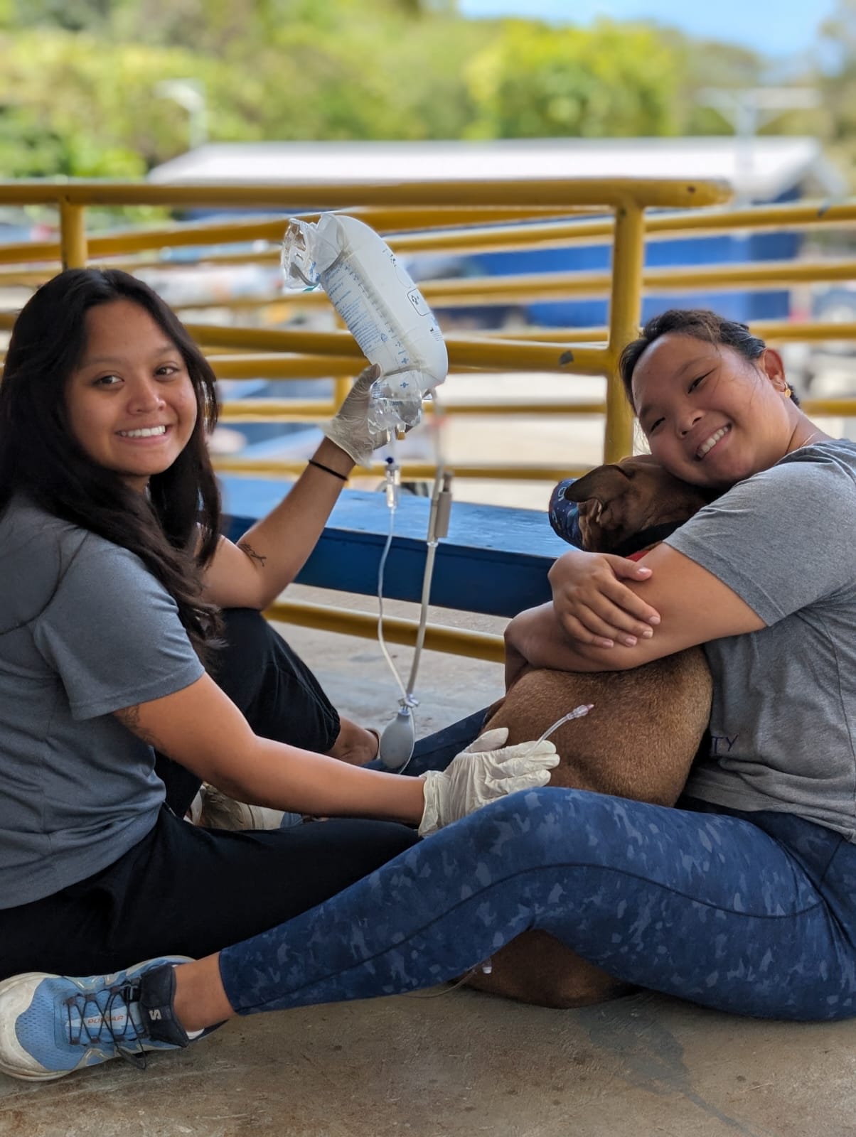 Jehniffer Villagomez, left, and clinic manager Ruby Ma, right, are all smiles as they assist a dog at a recently concluded spay and neuter clinic.