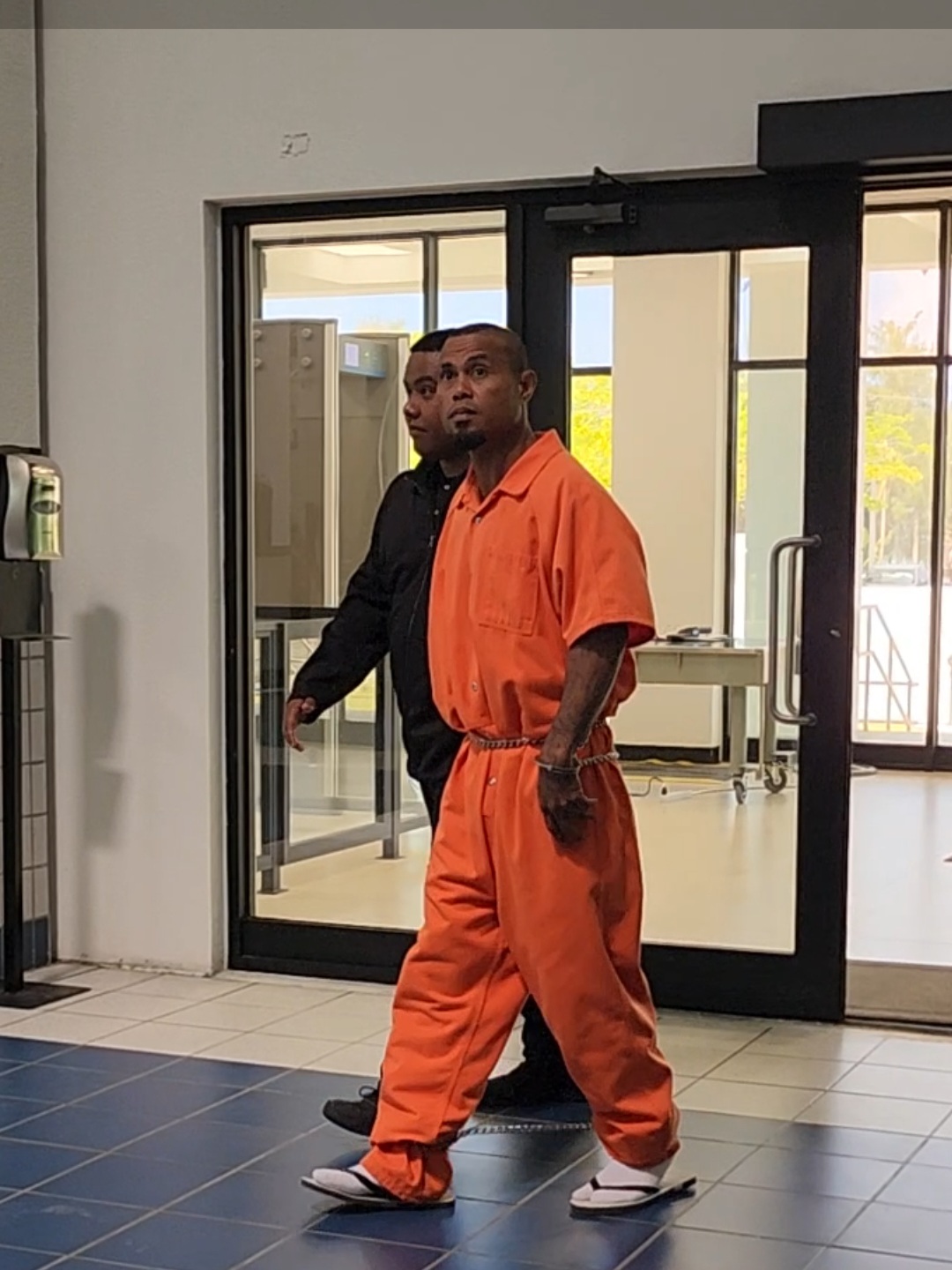 Lucky Michael Chipuelong is escorted by a Corrections officer at the courthouse for a bail hearing on April 8, 2024.