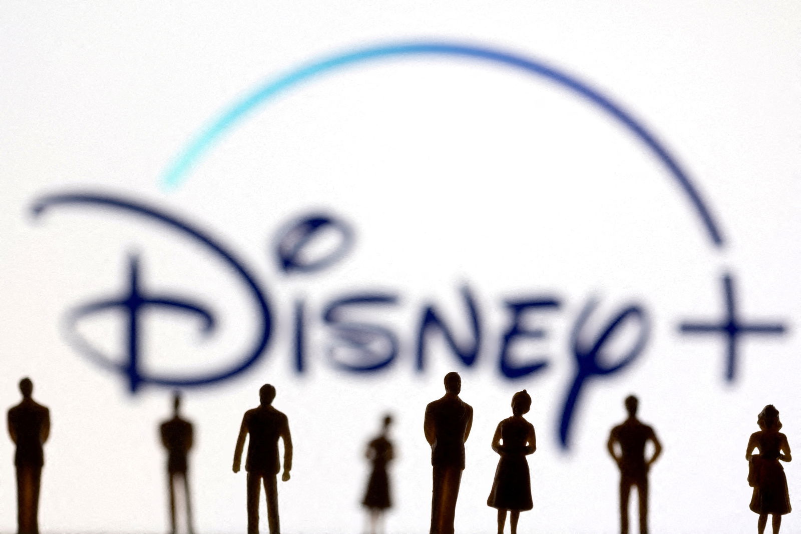 FILE PHOTO: Toy figures of people are seen in front of the displayed Disney + logo, in this illustration taken January 20, 2022. 