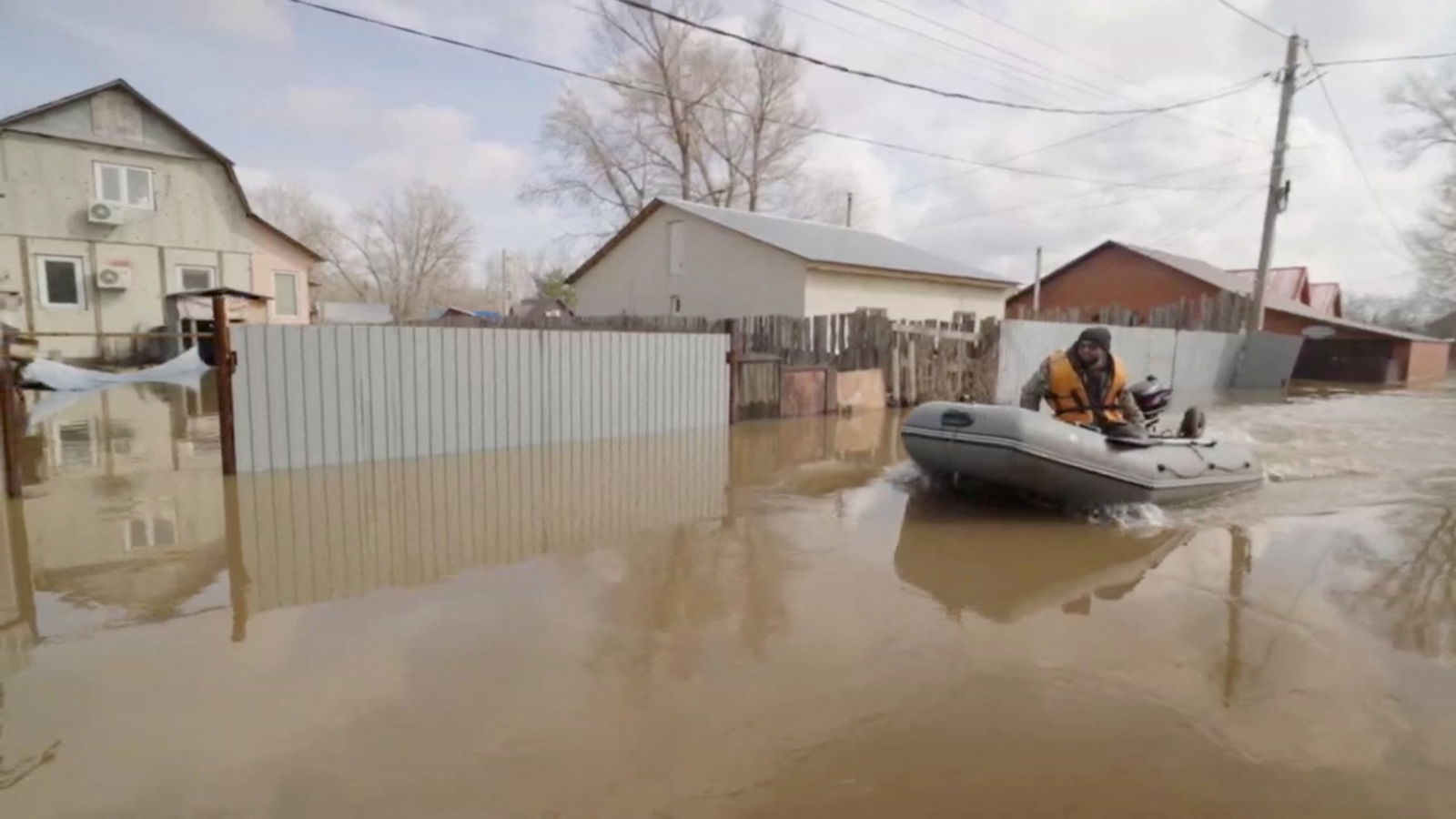 A man rides a boat in a flooded street in Orenburg, Russia, in this still image taken from video released April 8, 2024. 