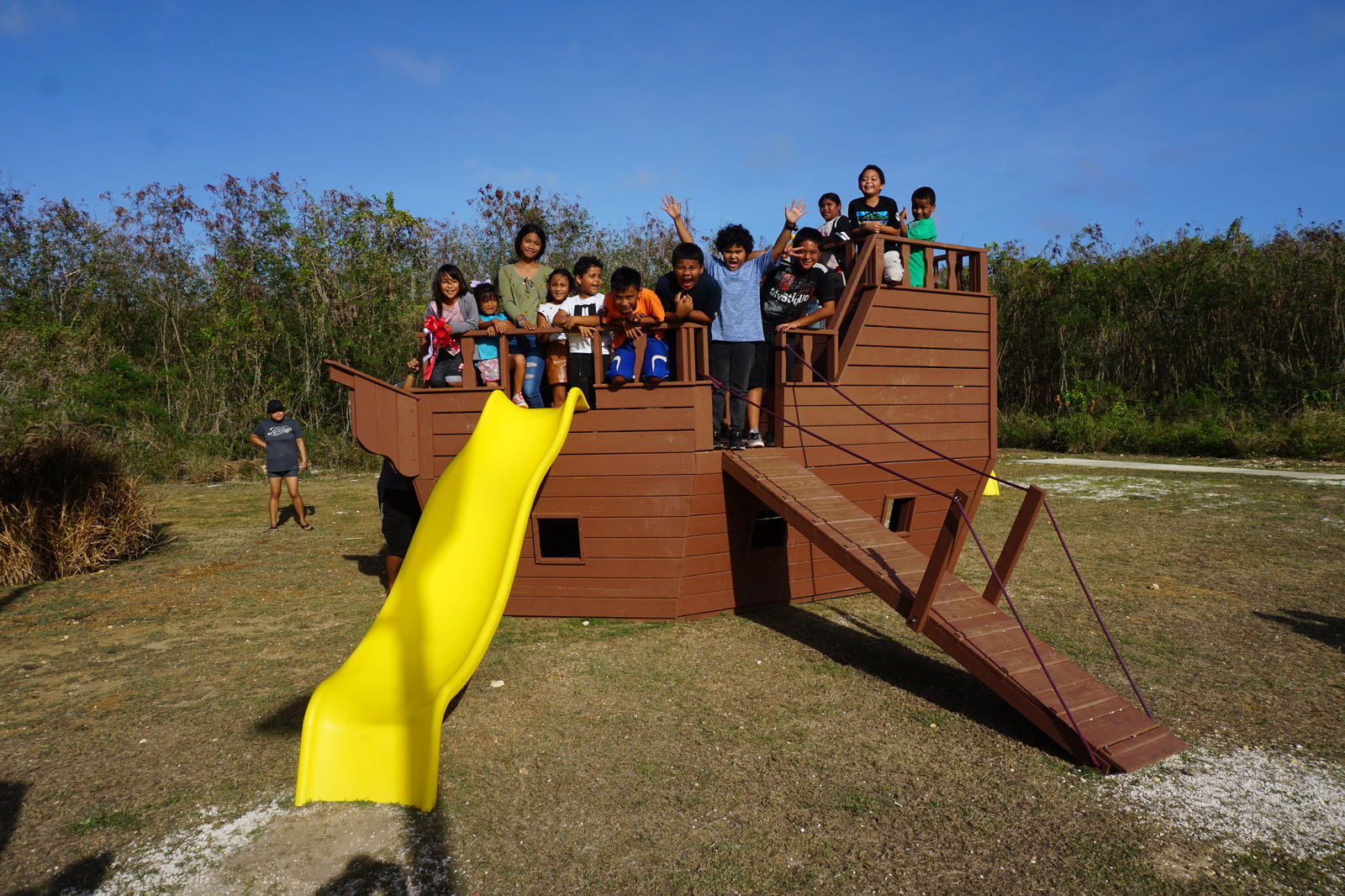Children say “cheese” aboard a newly installed playground equipment at the Kagman Community Center.