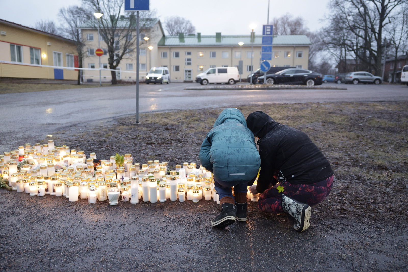 People bring candles and flowers at the Viertola school in Vantaa, Finland, on April 2, 2024. One sixth grade pupil died and two others were seriously injured in a shooting incident at the school on Tuesday morning. The suspect is also a 12-year-old pupil at the school. 