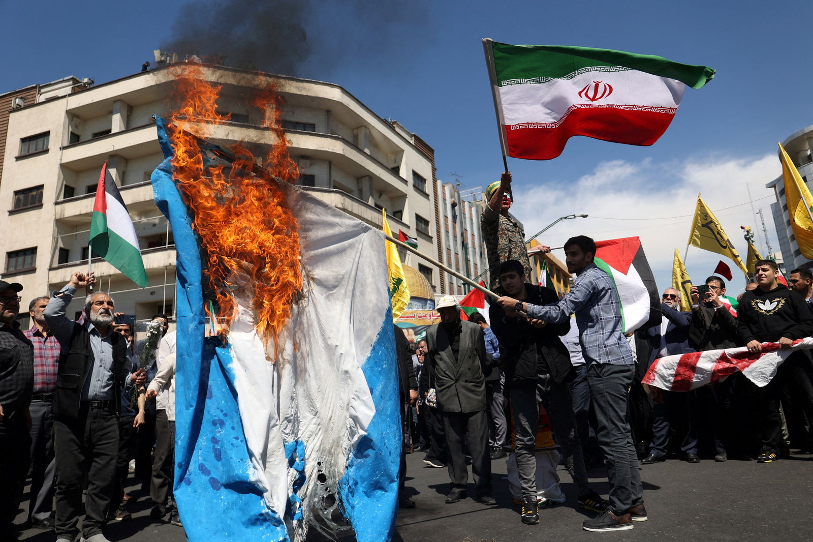 FILE PHOTO: Iranians burn an Israeli flag during a rally marking Quds Day and the funeral of members of the Islamic Revolutionary Guard Corps who were killed in a suspected Israeli airstrike on the Iranian embassy complex in the Syrian capital Damascus, in Tehran, Iran, April 5, 2024.