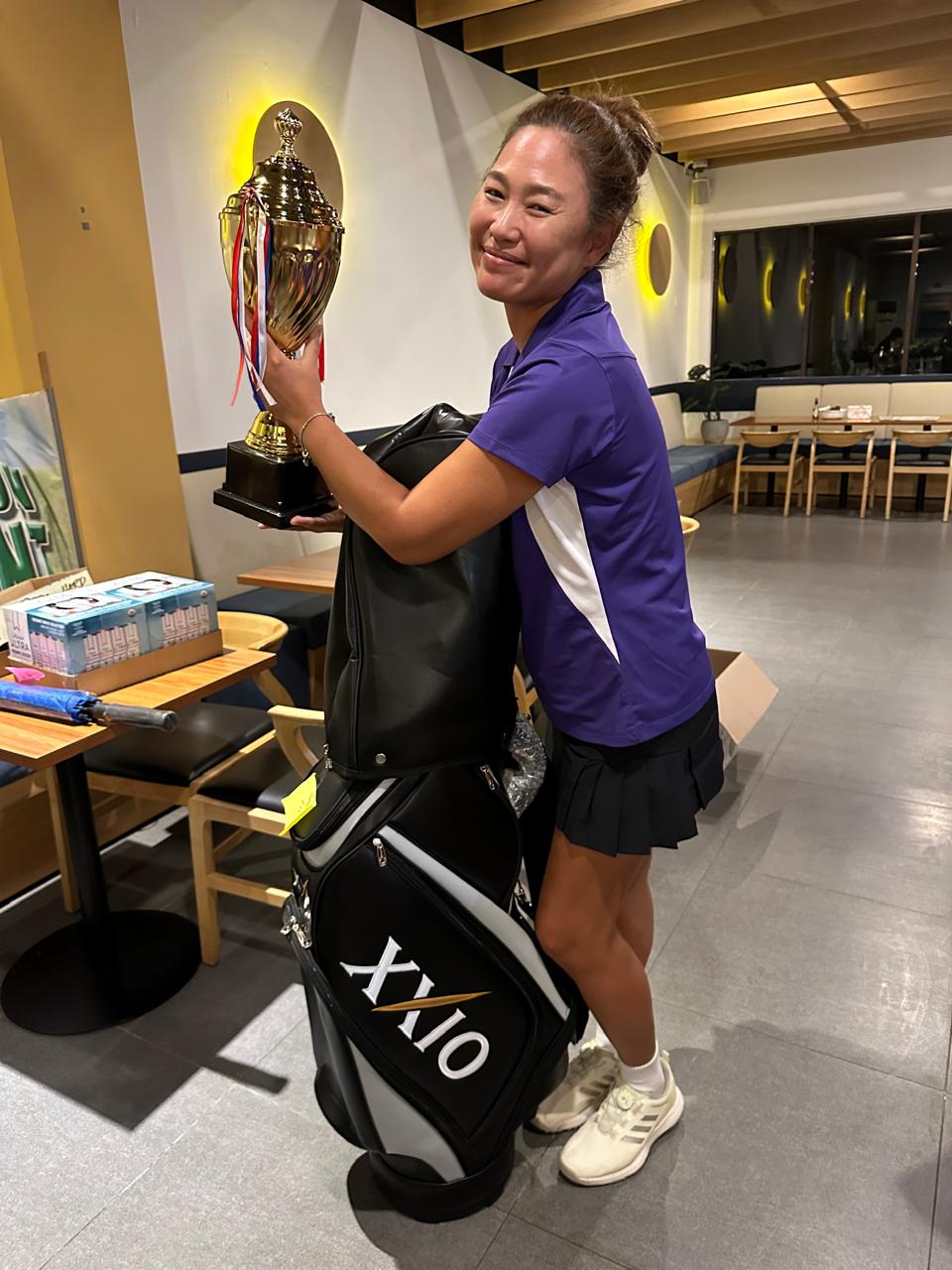Sae Hee Kim smiles as she holds the trophy and golf bag she received after winning CWGA's annual two-day tournament at the Kingfisher Golf Links over the weekend.