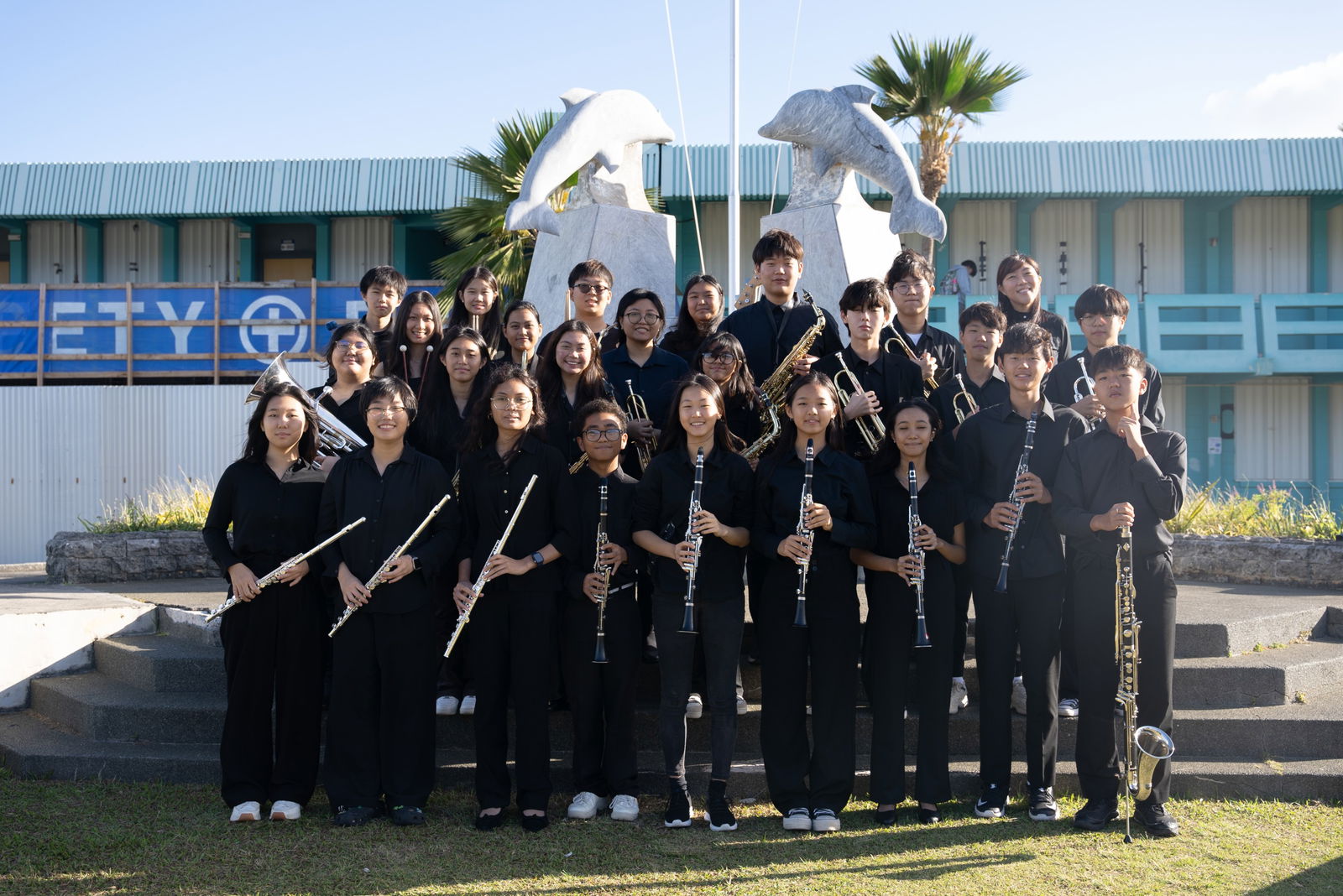 MHS Dolphin Concert Band members pose for a photo at the MHS Dolphin Monument.