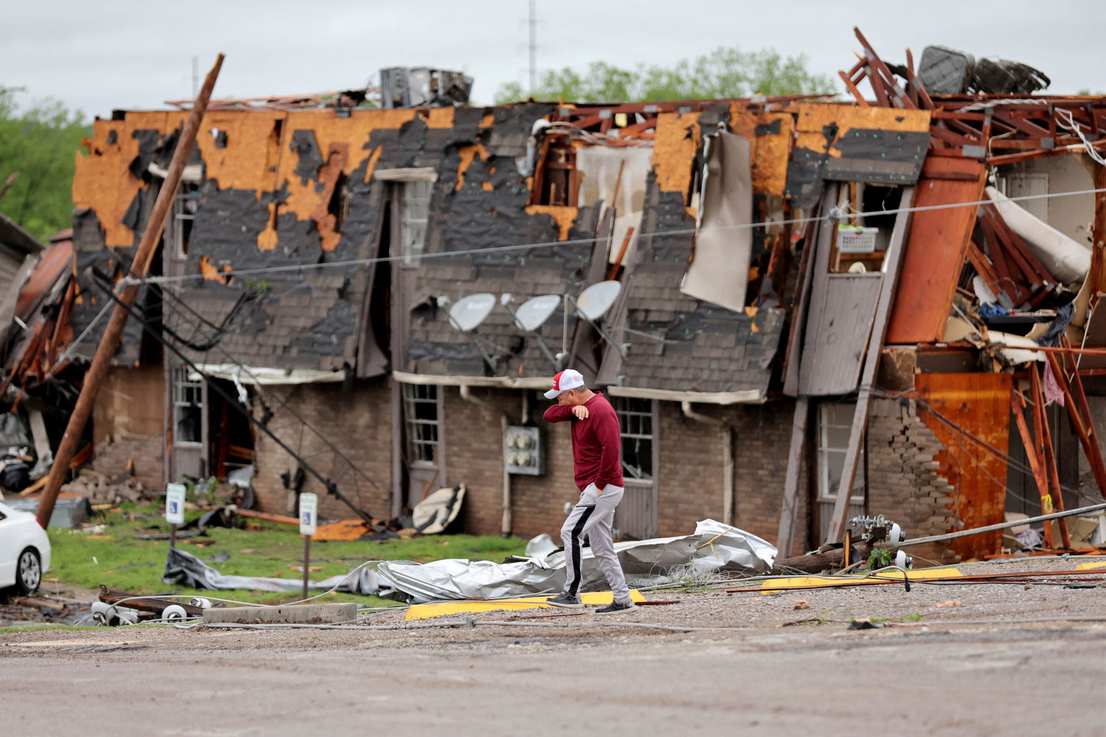 A man walks past a damaged building after it was hit by a tornado the night before in Sulphur, Oklahoma, April 28, 2024.