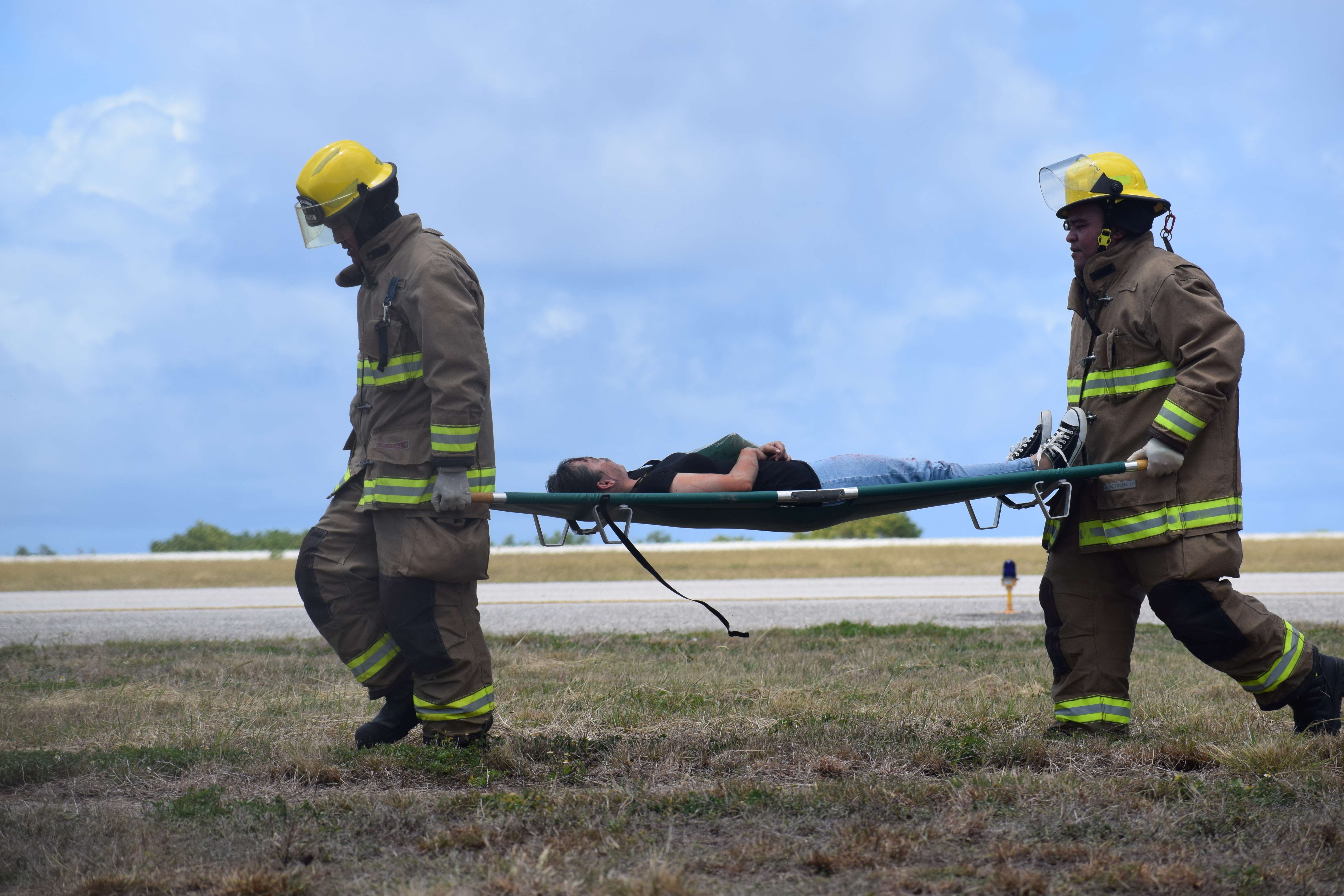ARFF rescuers transport a “plane crash survivor” to safety.