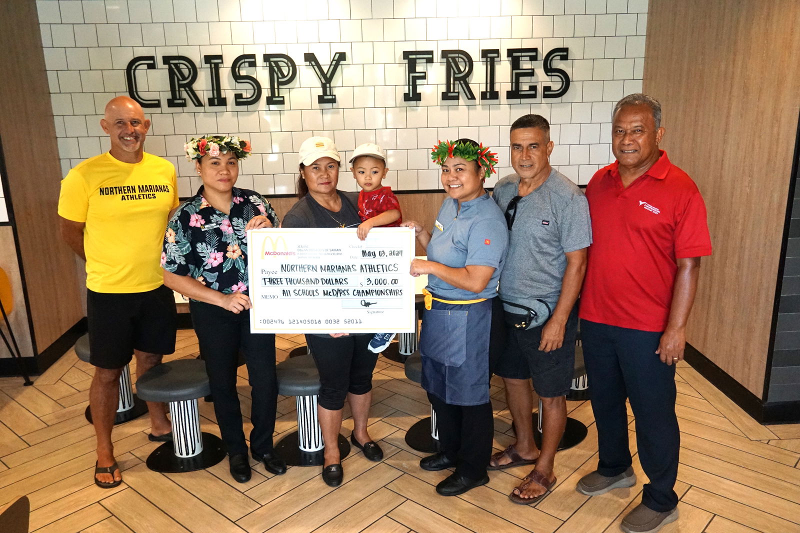 Public School System Athletics Program Director Nick Gross, left, along with the Northern Marianas Athletics President Ramon Tebuteb, right, and NMA coach/developmental officer Elias Rangamar, second right, pose for a photo with McDonald’s of Saipan’s vice president and owner/operator Marcia Ayuyu, third left, who donated a check for $3,000 to the McDonald's-PSS All Schools Track and Field (Athletics) SY 23-24 at the McDonald's Middle Road branch on Friday.