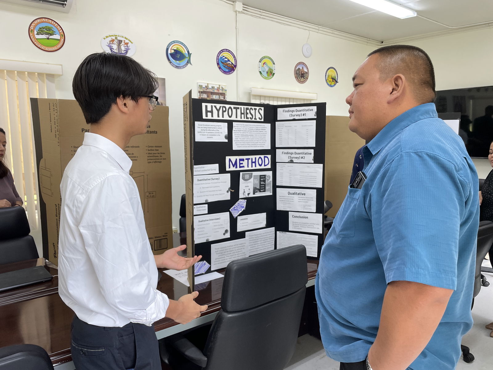SSHS AP student Tao Jin discusses his research work on the social-emotional learning programs implemented in schools following the Covid-19 pandemic with Associate Commissioner for Administrative Services Eric Magofna.