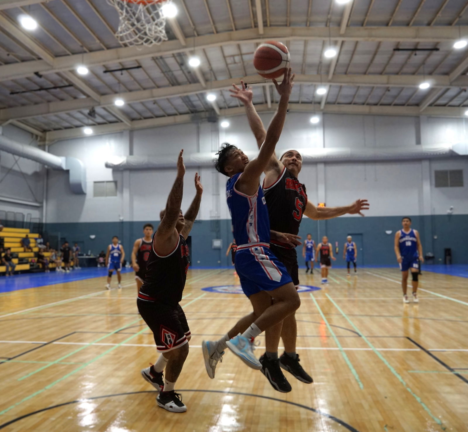 New Changming's Ronald Bernardo extends for the reverse finish between two defenders during a game against Bridge Capital in the Michelob Ultra Cup 2024 at the Ada gym on Monday.