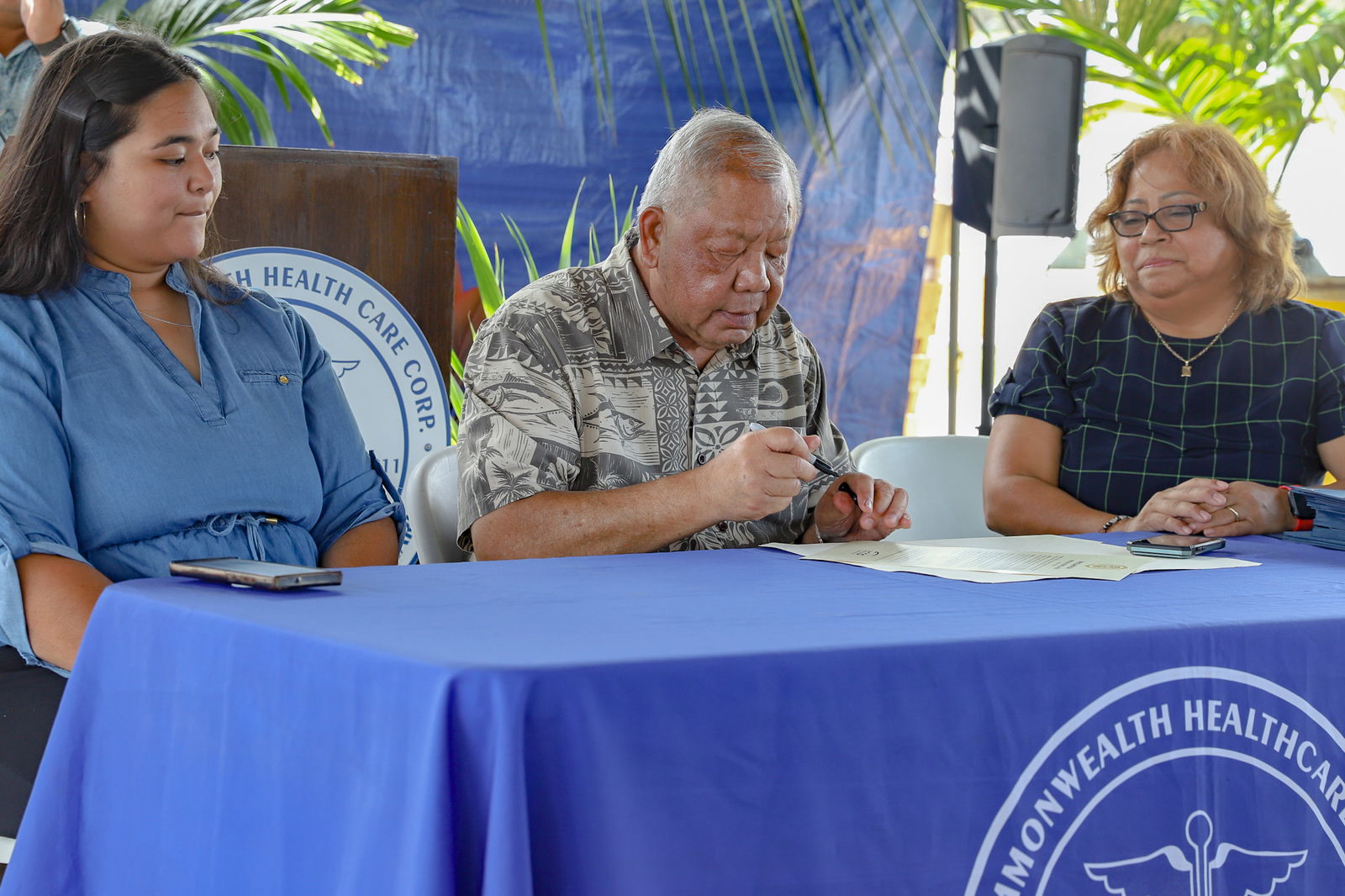Lt. Gov. David M. Apatang, center, signs the National Hospital Week proclamation as Commonwealth Healthcare Corp. Chief Executive Officer Esther Muna, right, and CHCC board member Mariah Barcinas, left, look on, Thursday, May 9, 2024.