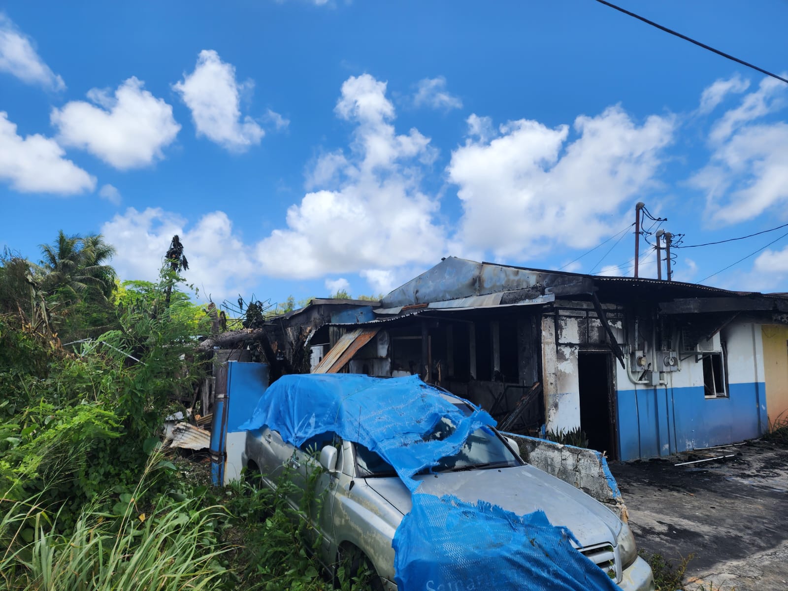 A fire that broke out from a nearby auto shop damaged this house in Susupe.
