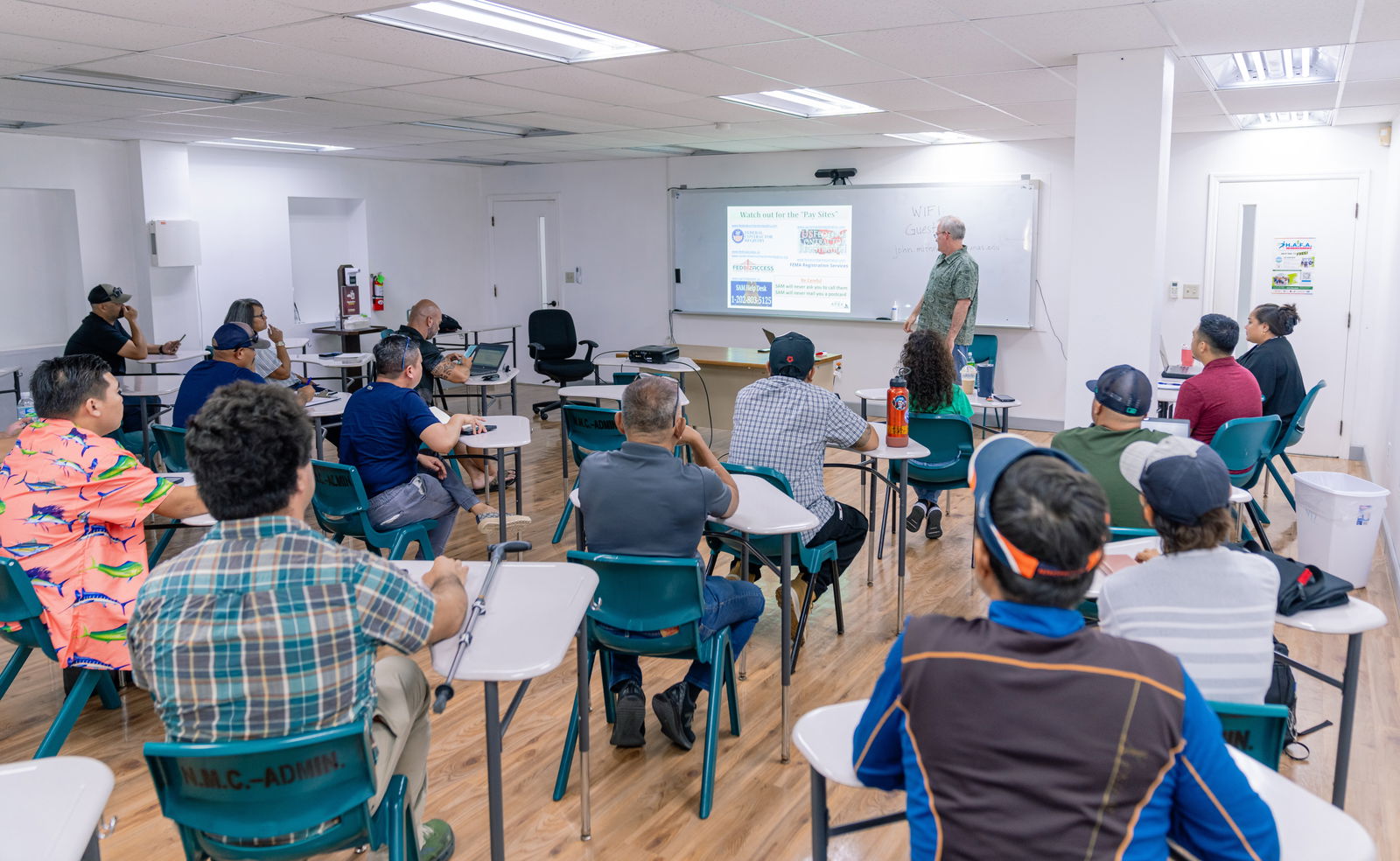 Trainees listen as Boris Hertslet presents on one of the federal contracting requirements.