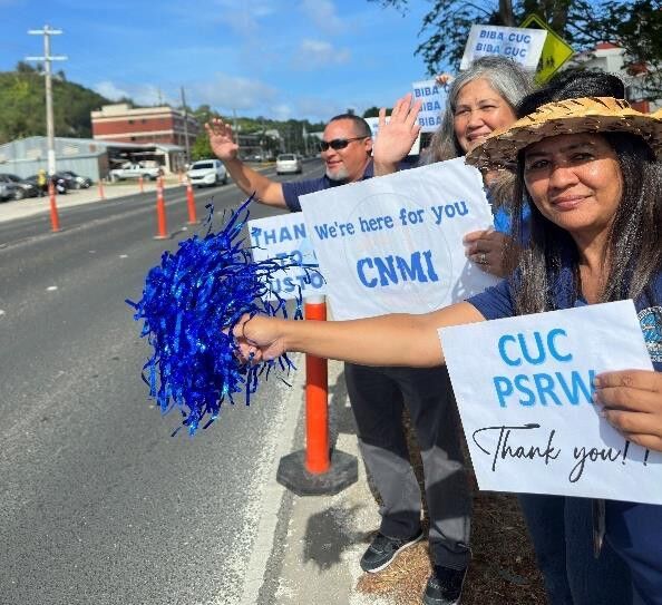 CUC Saipan employees capture the spirit of unity and celebration with their bright smiles and colorful posters.