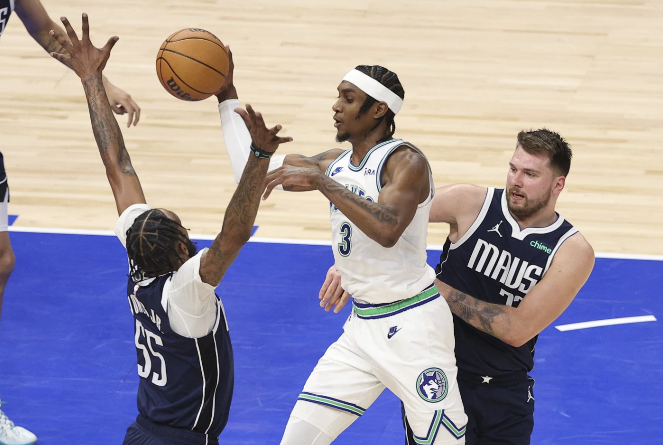 Minnesota Timberwolves forward Jaden McDaniels (3) drives between Dallas Mavericks forward Derrick Jones Jr. (55) and guard Luka Doncic, right, during Game 1 of the NBA Western Conference finals, Wednesday, May 22, 2024.