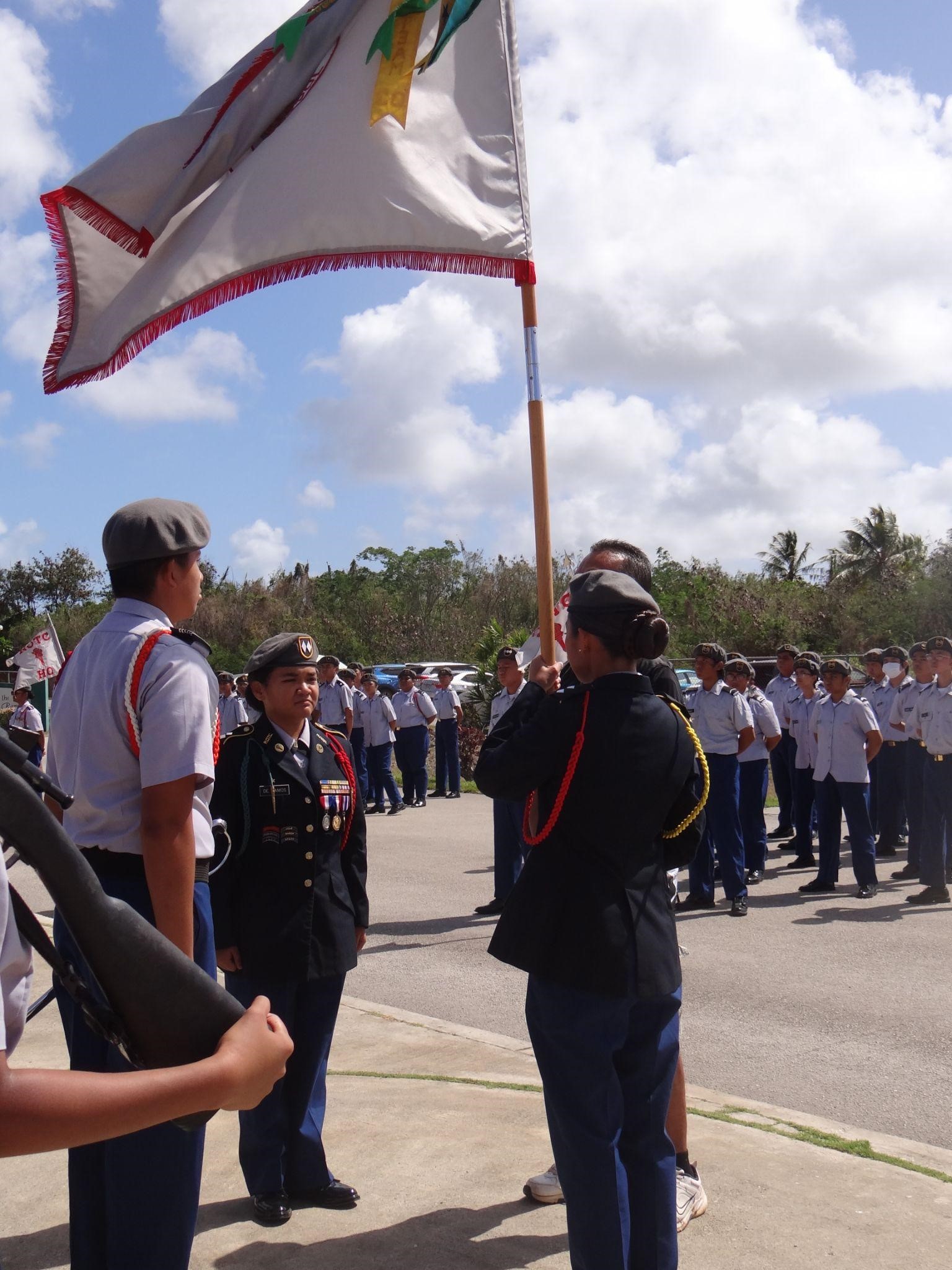The incoming battalion commander receives the battalion colors from the battalion CSM, the outgoing battalion commander, and the SSHS principal.