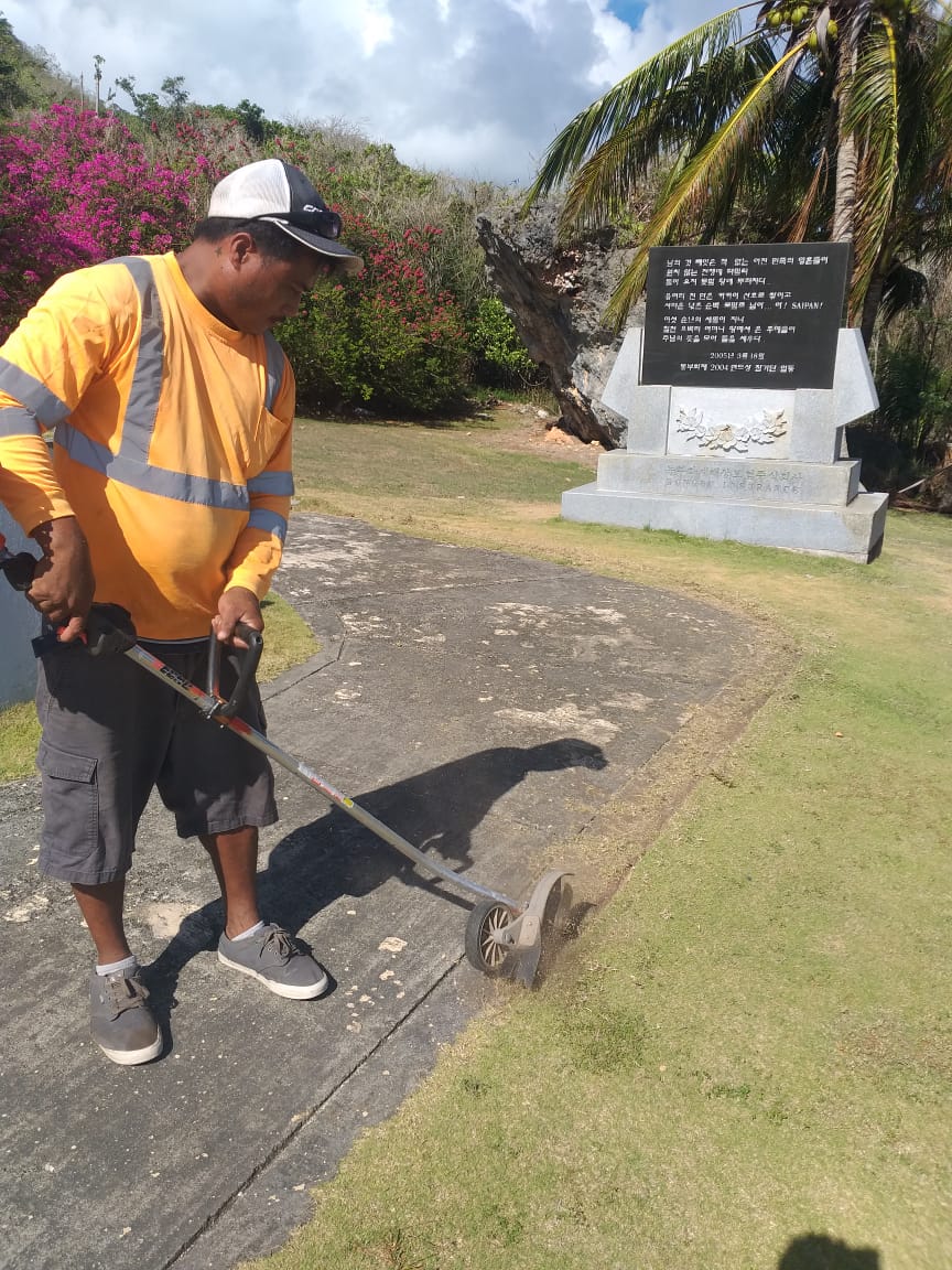 Jeffrey David of LJ Lawn Care edges a sidewalk at the Korean Memorial  as part of the company's community service  to enhance  the Korean,  Okinawan, and Japanese  memorials  in  Marpi.  The project was also supported by the Marianas Visitors  Authority  Destination  Enhancement  Division  and volunteers from Women's National  Team  of the Northern Mariana  Islands  Football  Association.