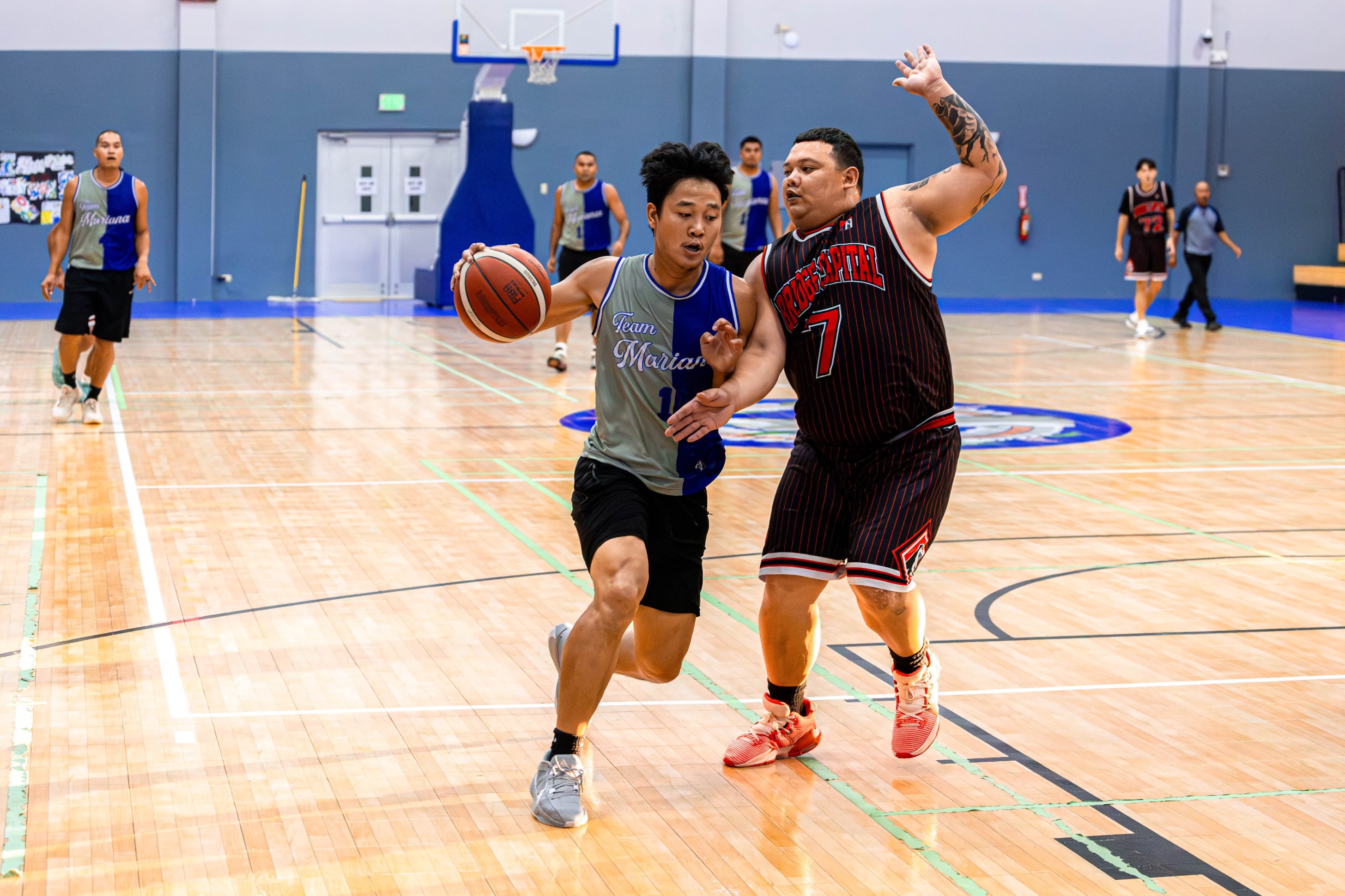 Team Marianas' Coby Santos makes contact with Bridge Capital's Matt Duenas as he attempts to drive down the lane during a semifinal game against Bridge Capital in the Michelob Ultra Cup 2024 at the Ada gym on Wednesday.