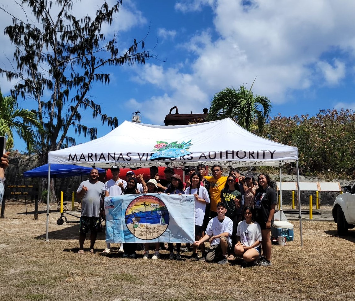 Marianas Visitors Authority Rota Field Operations Supervisor David Atalig, left, organizes students of the National Honor Society of Dr. Rita H. Inos Jr./Sr. High School in Rota in a community projector on May 11, 2024, to celebrate Marianas Tourism Month. The students repainted a historic sugar industry train engine dating back to the Japanese administration of the islands in the early 1900s.