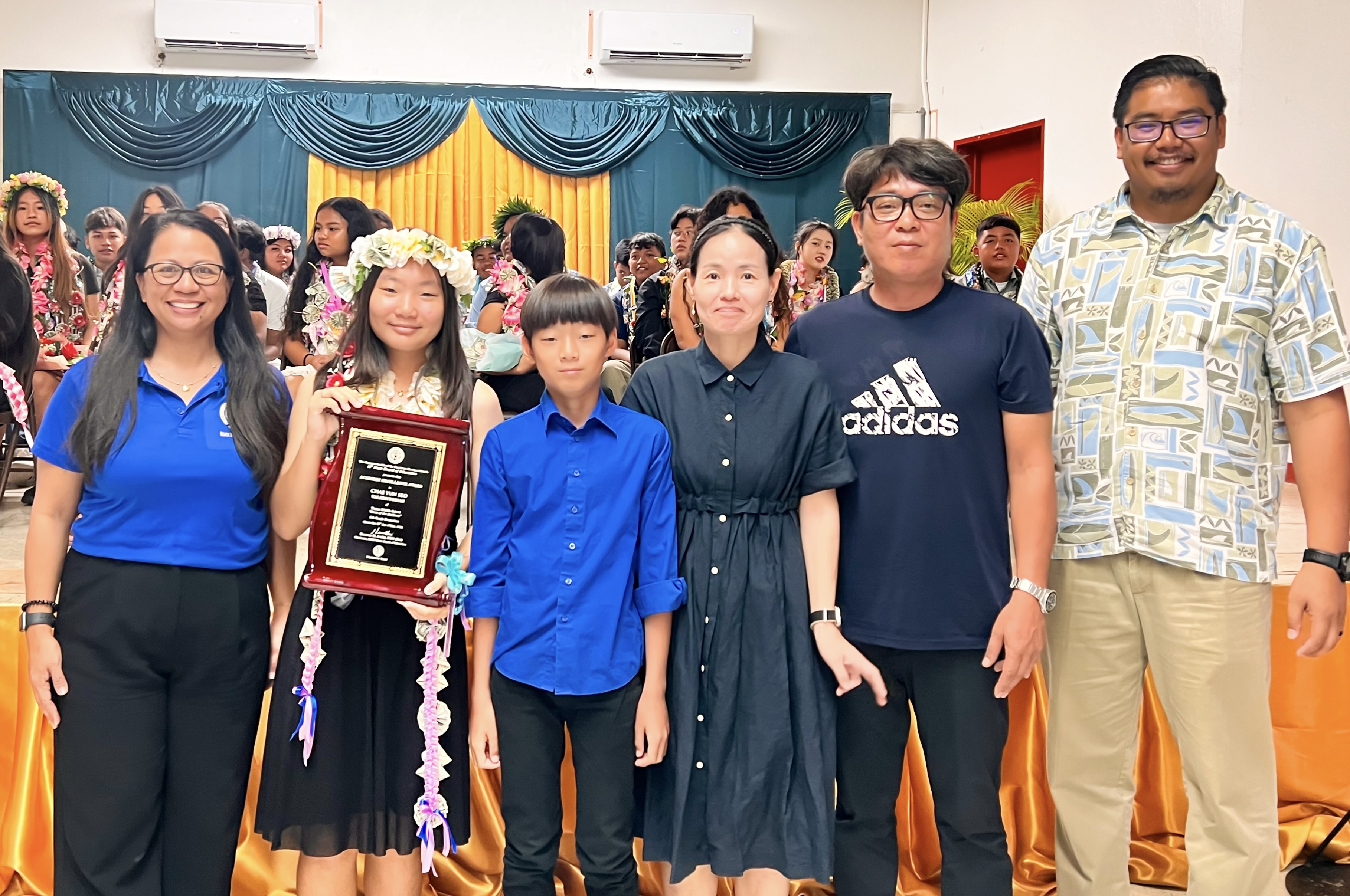 Class valedictorian Chae Yun Seo, joined by her parents and brother, is presented with the Board of Education Academic Excellence Award by Acting BOE Chair Maisie B. Tenorio and BOE member Antonio Toram Borja.