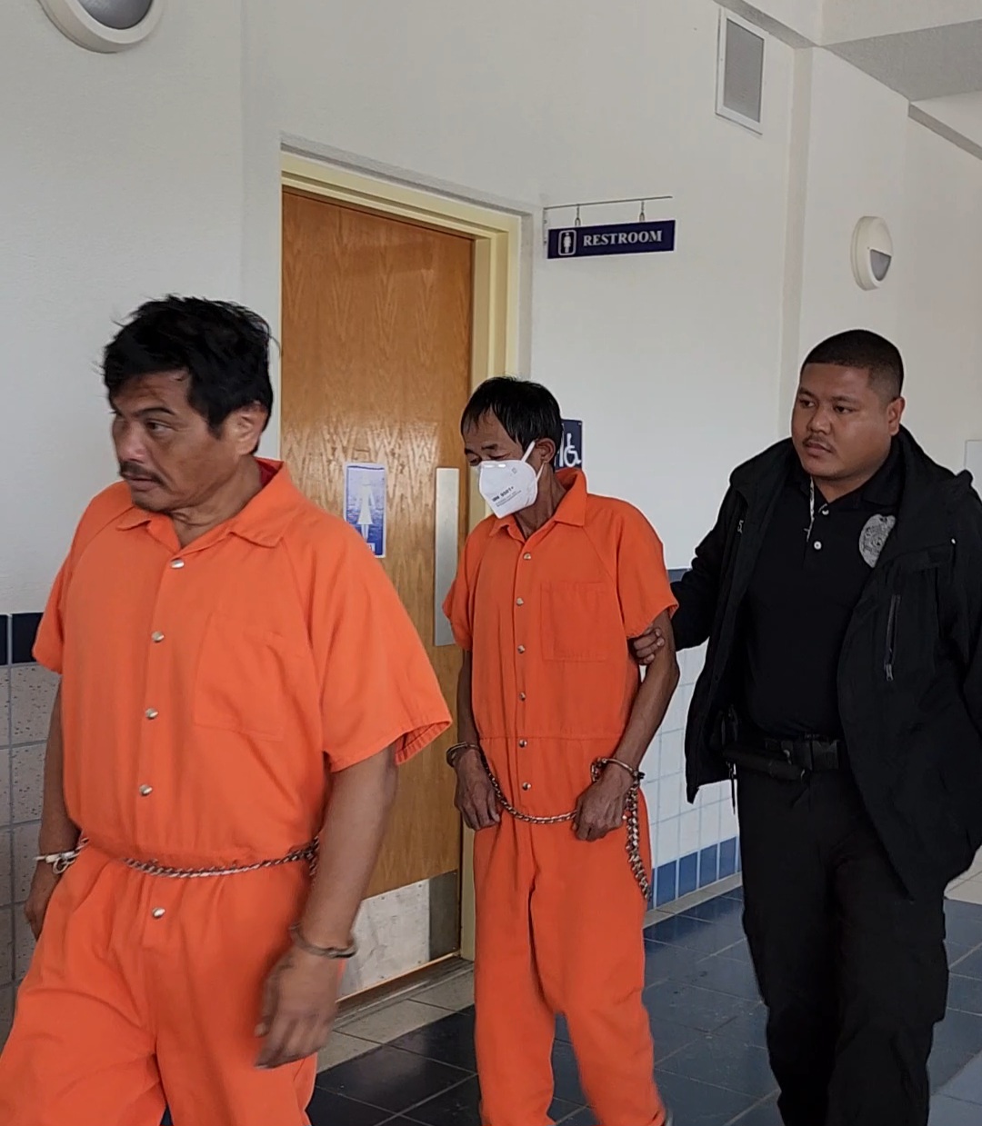 Daniel Aldan Castro, left, walks toward Courtroom 220 for a preliminary hearing on Monday. Behind him is Xian Xi Li, another defendant, escorted by a Corrections officer.