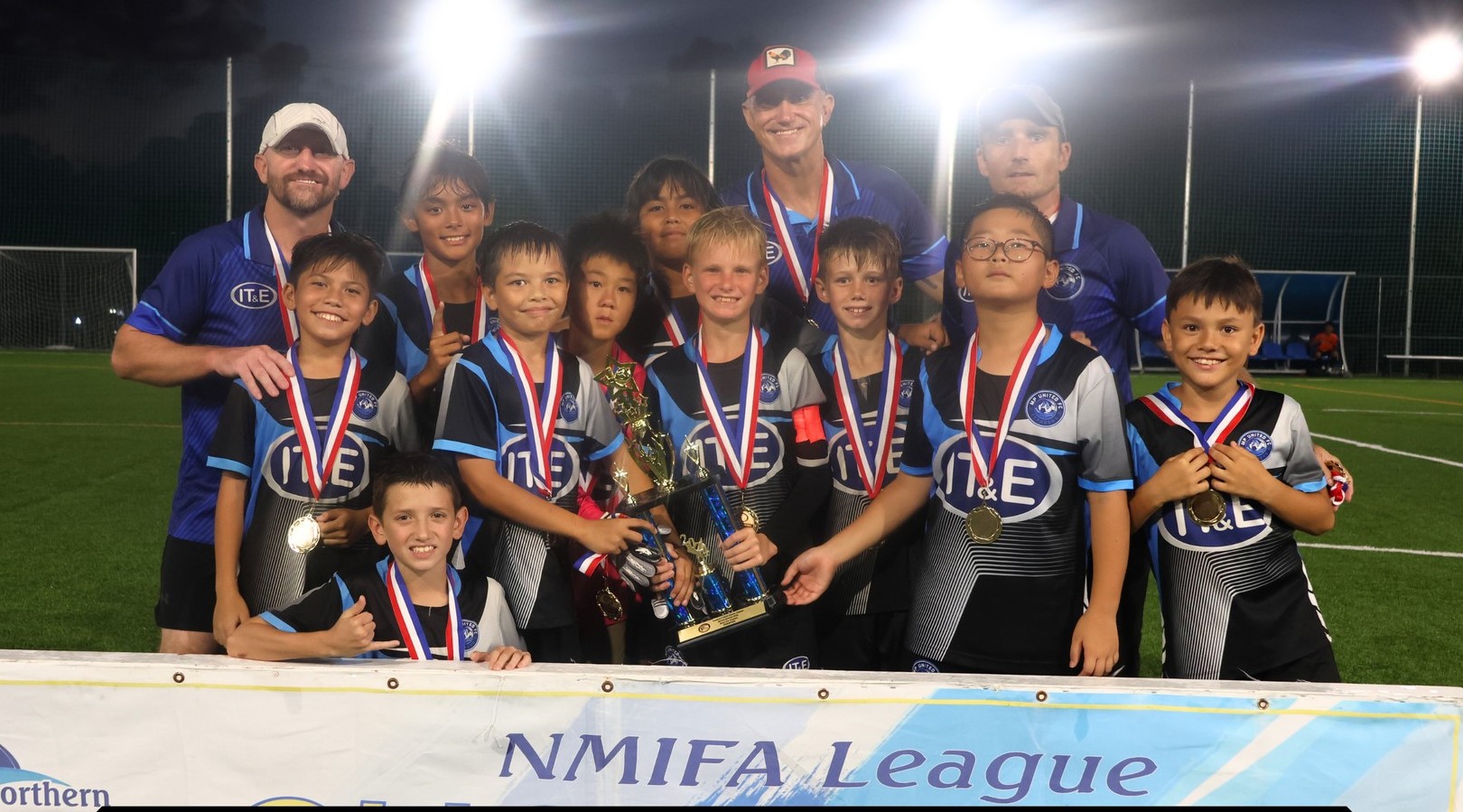 The MP United Football Club players pose with the U12 boys division championship trophy after defeating Kanoa FC in an overtime shootout during the finale of the TakeCare Youth Soccer League Spring 2024 at the NMI Soccer Training Center in Koblerville on Saturday.