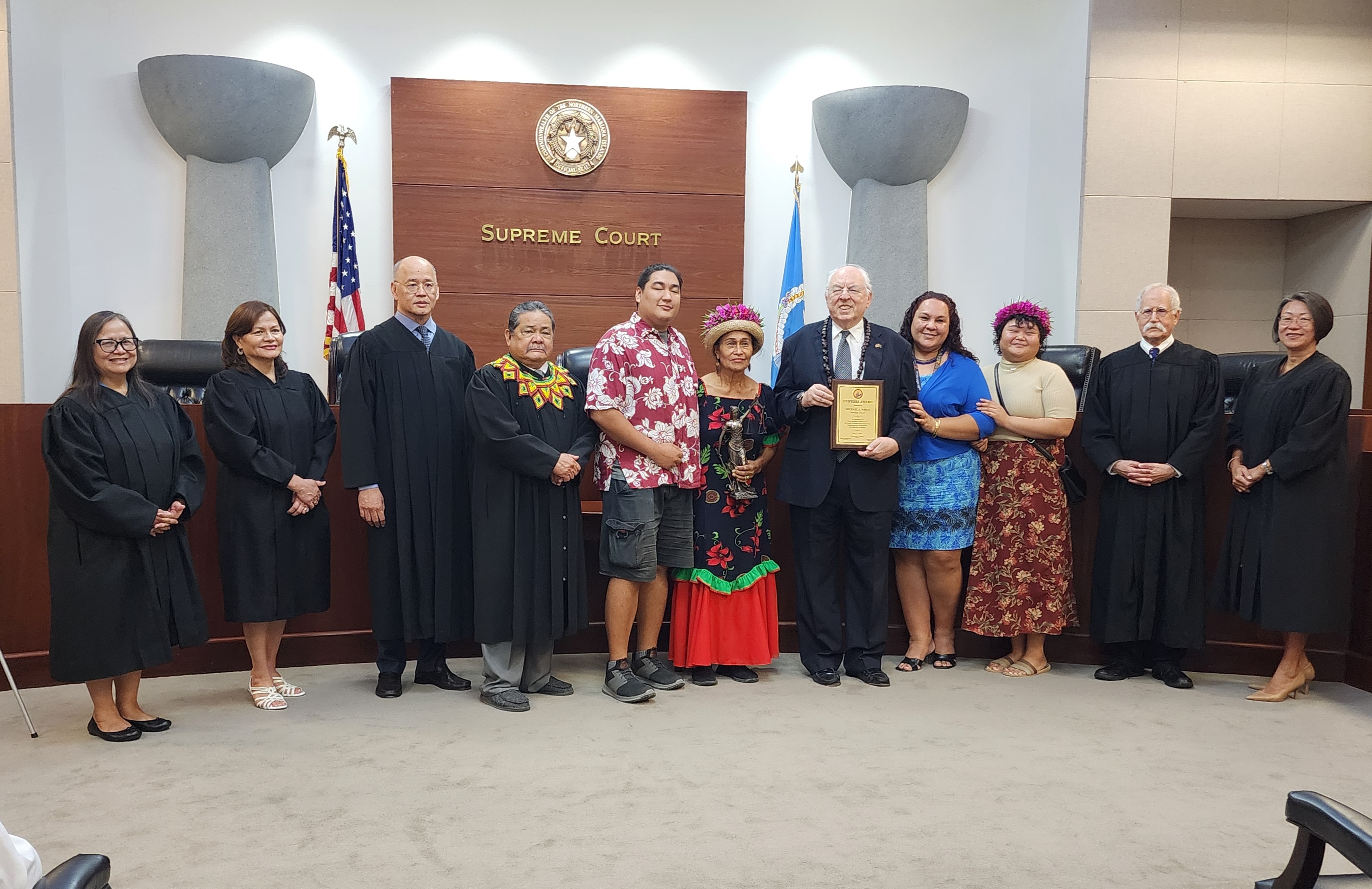 Supreme Court Hustisia Award recipient, attorney Michael White with wife Rose White and their children pose for a photo with Judge Lilian Ada Tenorio, Judge Kenneth L. Govendo, Judge Teresa Kim-Tenorio, Justice John Manglona, Chief Justice Alexandro Castro and District Court for the NMI Chief Judge Ramona V. Manglona in the CNMI Supreme Court courtroom, Friday, May 17.