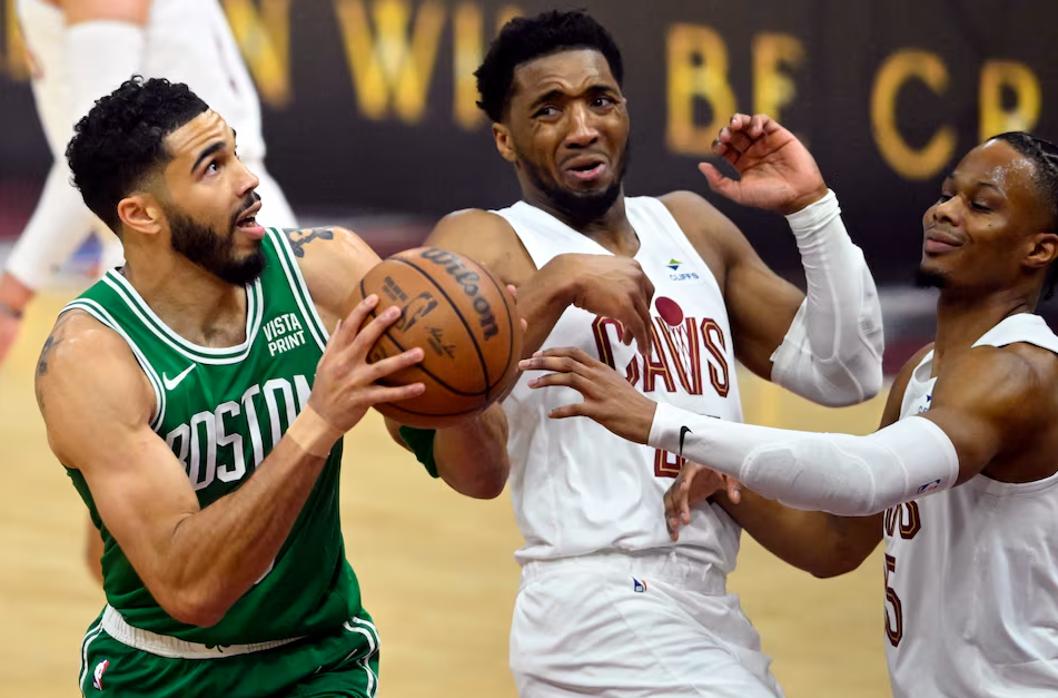 Boston Celtics forward Jayson Tatum (0) drives against Cleveland Cavaliers guard Donovan Mitchell (45) and forward Isaac Okoro (35) in the first quarter of game three of the second round of the 2024 NBA playoffs at Rocket Mortgage FieldHouse in Cleveland, Ohio, May 11, 2024.