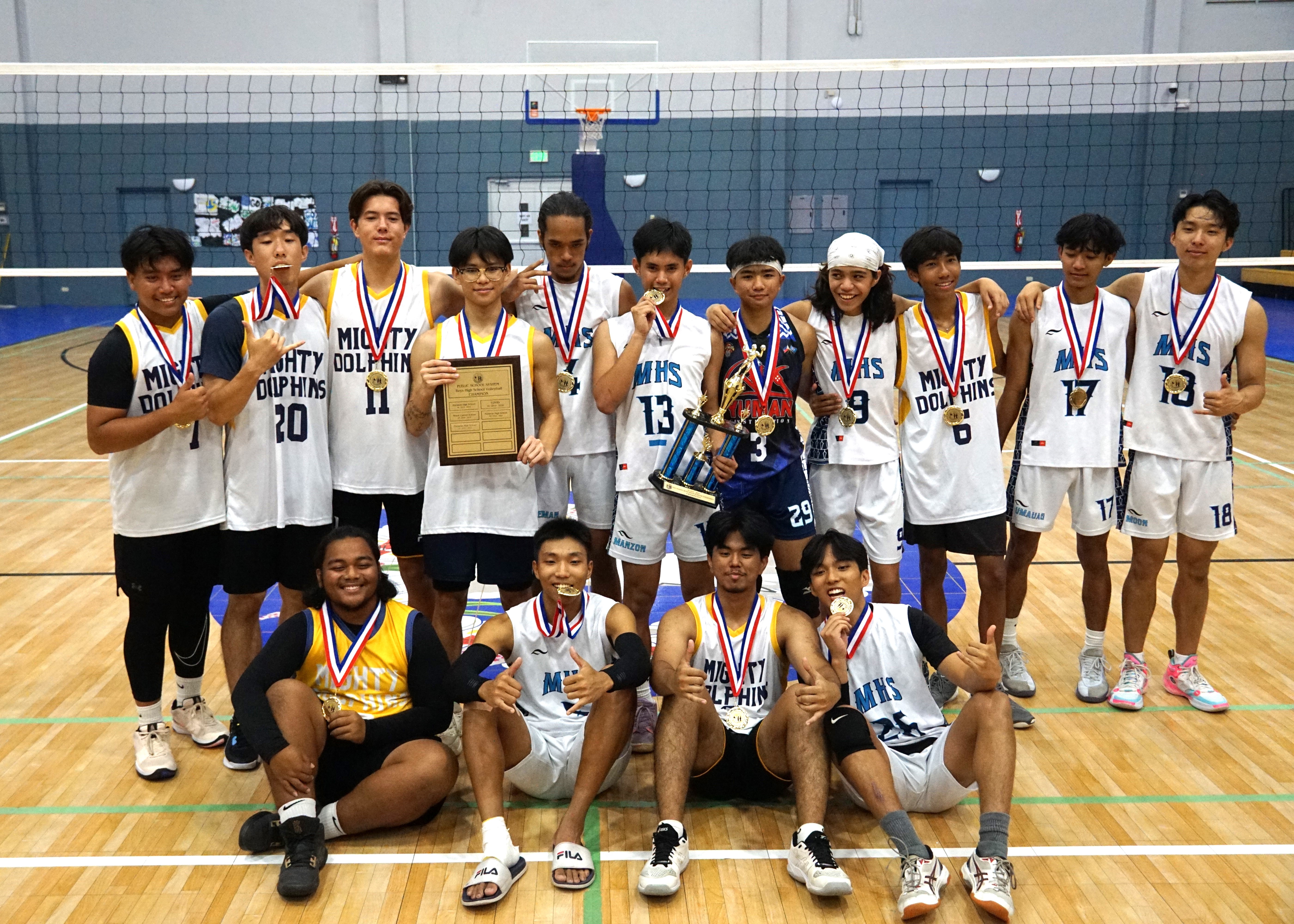 The Marianas High School volleyball players pose with their first-place medals and trophy.