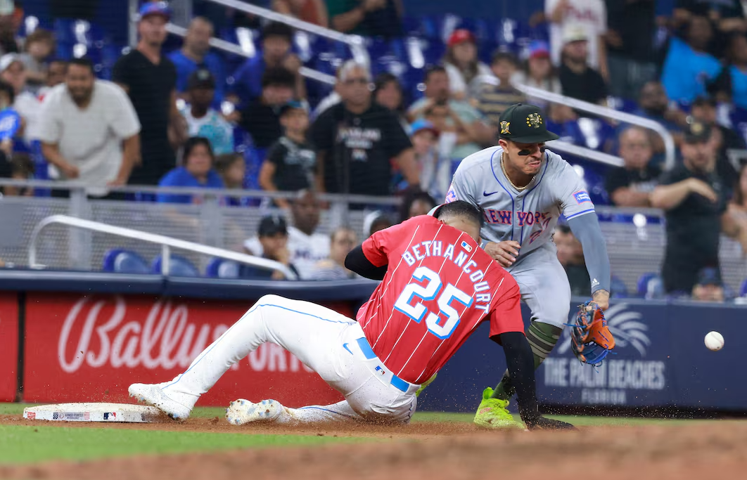 Miami Marlins catcher Christian Bethancourt (25) beats the throw to New York Mets third baseman Mark Vientos (27) in the tenth inning at loanDepot Park in Miami, Florida, May 18, 2024.
