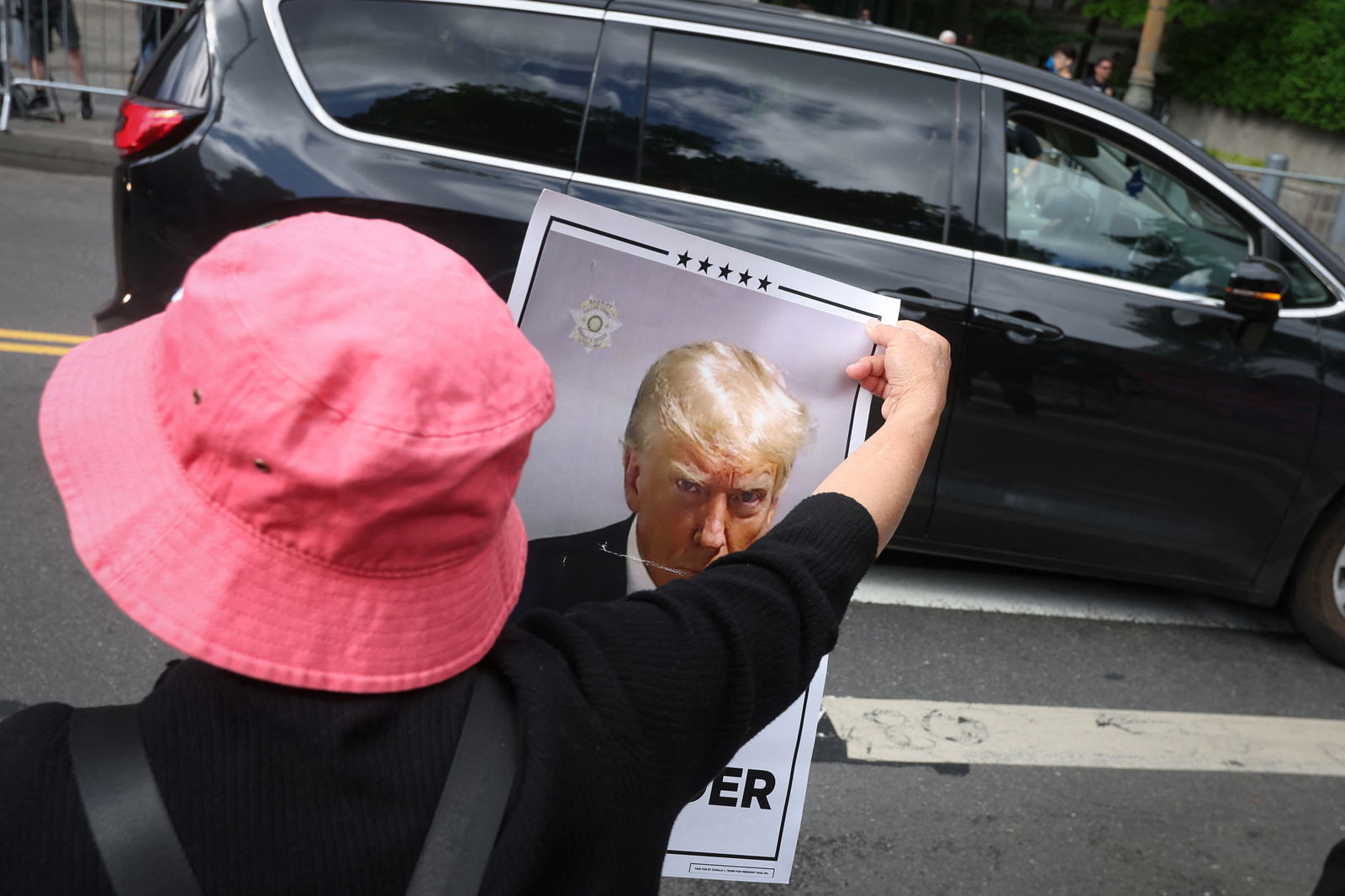 A supporter of former President Donald Trump stands along a sidewalk as Trump’s motorcade arrives at Manhattan criminal court for the 2nd day of jury deliberations in Trump’s criminal trial over charges that he falsified business records to conceal money paid to silence porn star Stormy Daniels in 2016, in New York City, May 30, 2024.