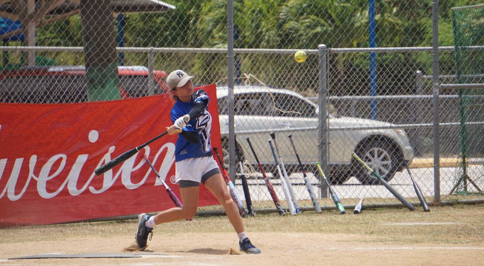 Kiana “Baby K” Camacho swings and connects in game 2 of the 2024 Budweiser Belau Amateur Softball Association League ladies division championship at the Dandan baseball field on Sunday.