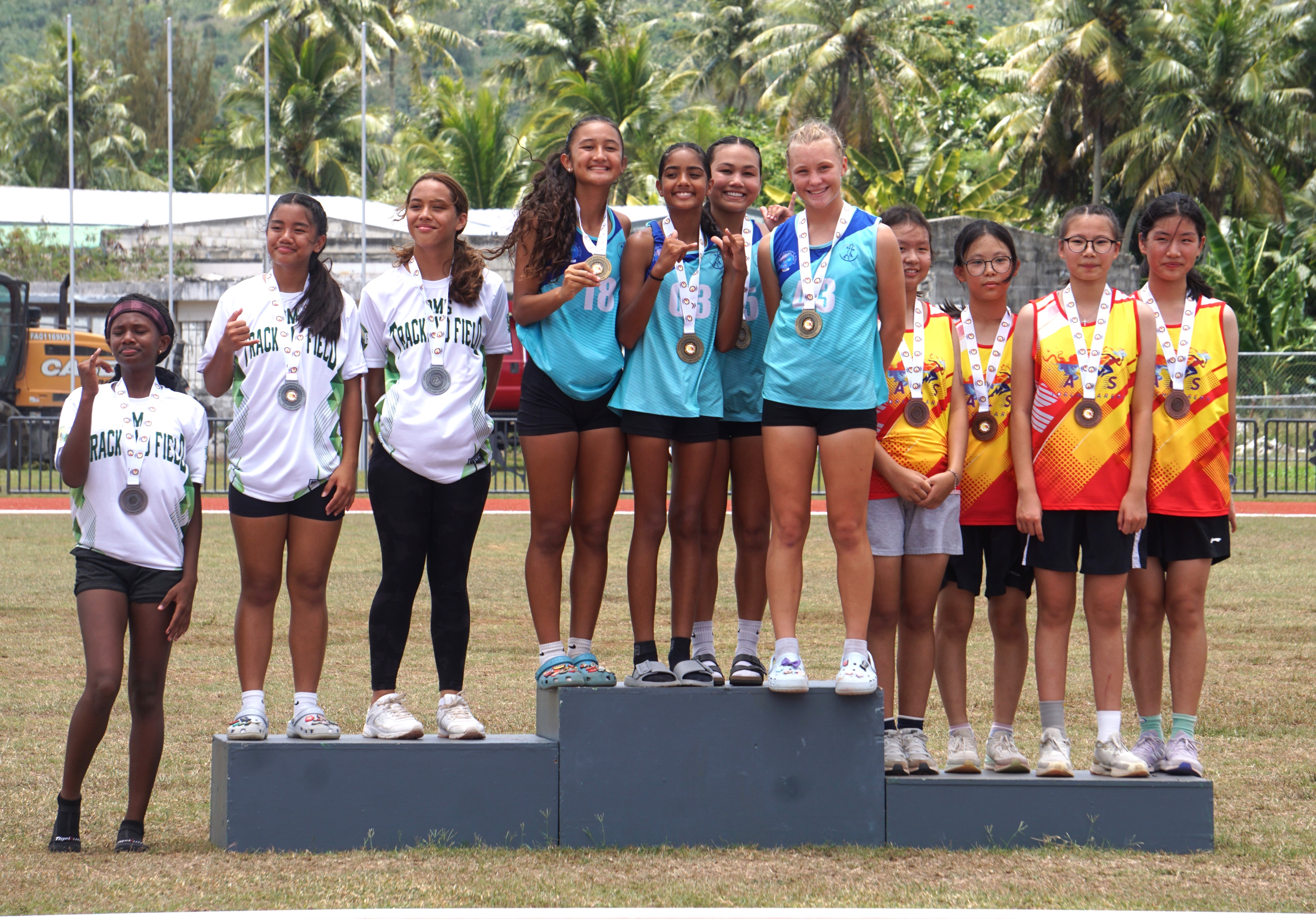 The athletes of Saipan International School, center, Dandan Middle School, left, and Agape Christian School pose for a photo during the awards ceremony for the girls middle school division’s 4x400m event of the McDonald's-PSS All School Track and Field (Athletics) SY23-24 at the Oleai Sports Complex on Saturday.
