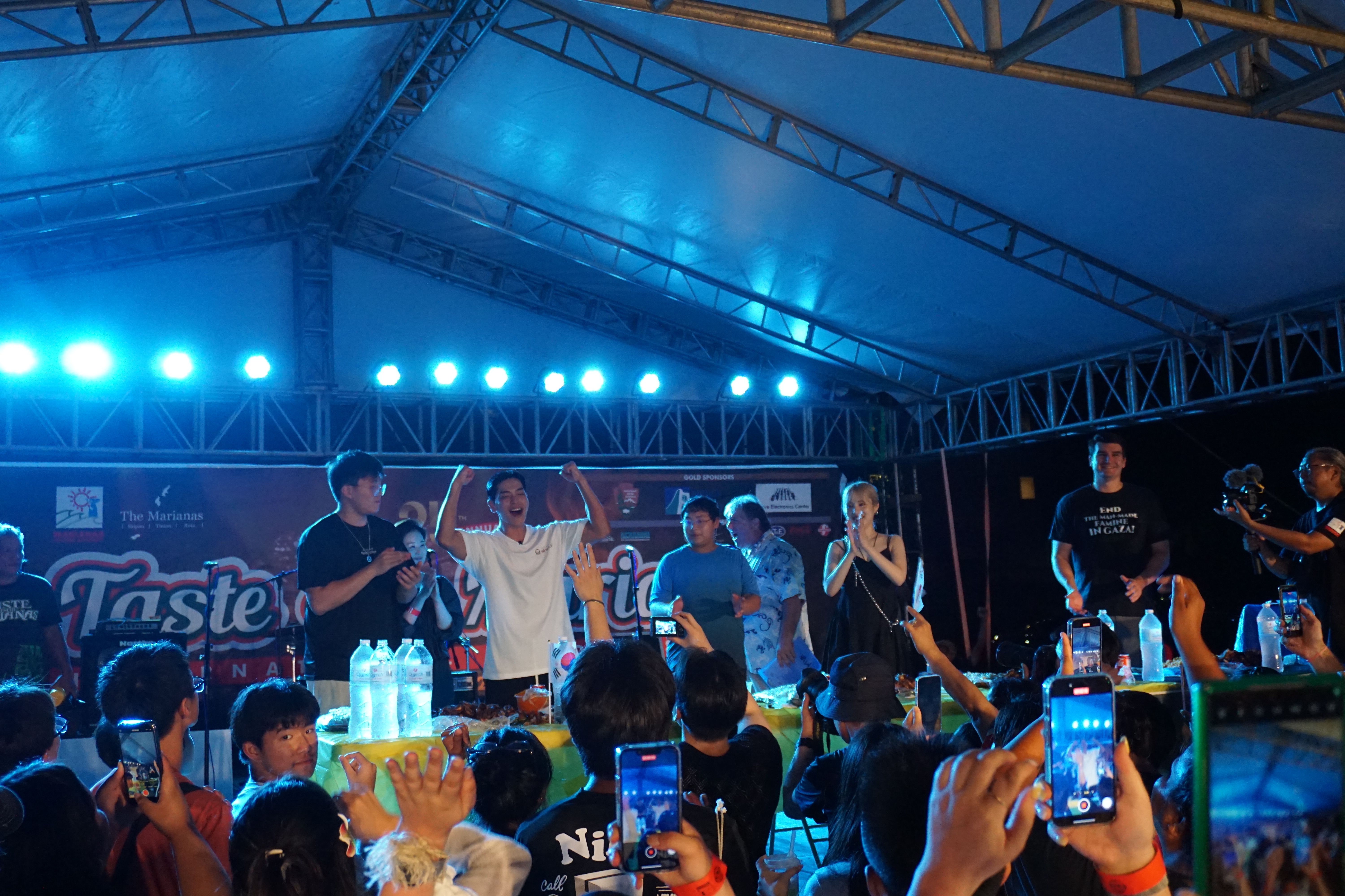 Korean pro competitive eater Sang Hyuk Kwon raises his hands after he was declared the top eater in the food challenge.