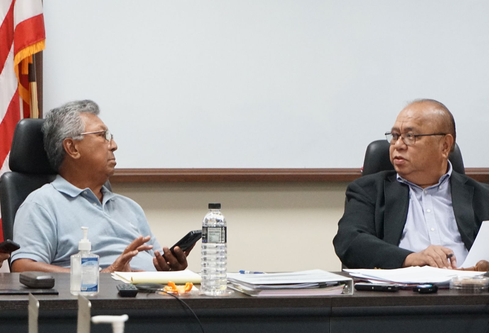 Commonwealth Casino Commission member Mario Taitano left, confers with Commission Chairman Edward C. Deleon Guerrero during their regular meeting in Gualo Rai last month.