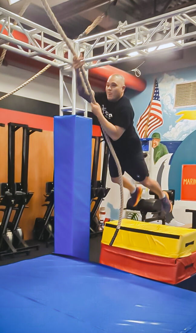 An athlete swings from a rope in a Sindalu Ninja Games demonstration.