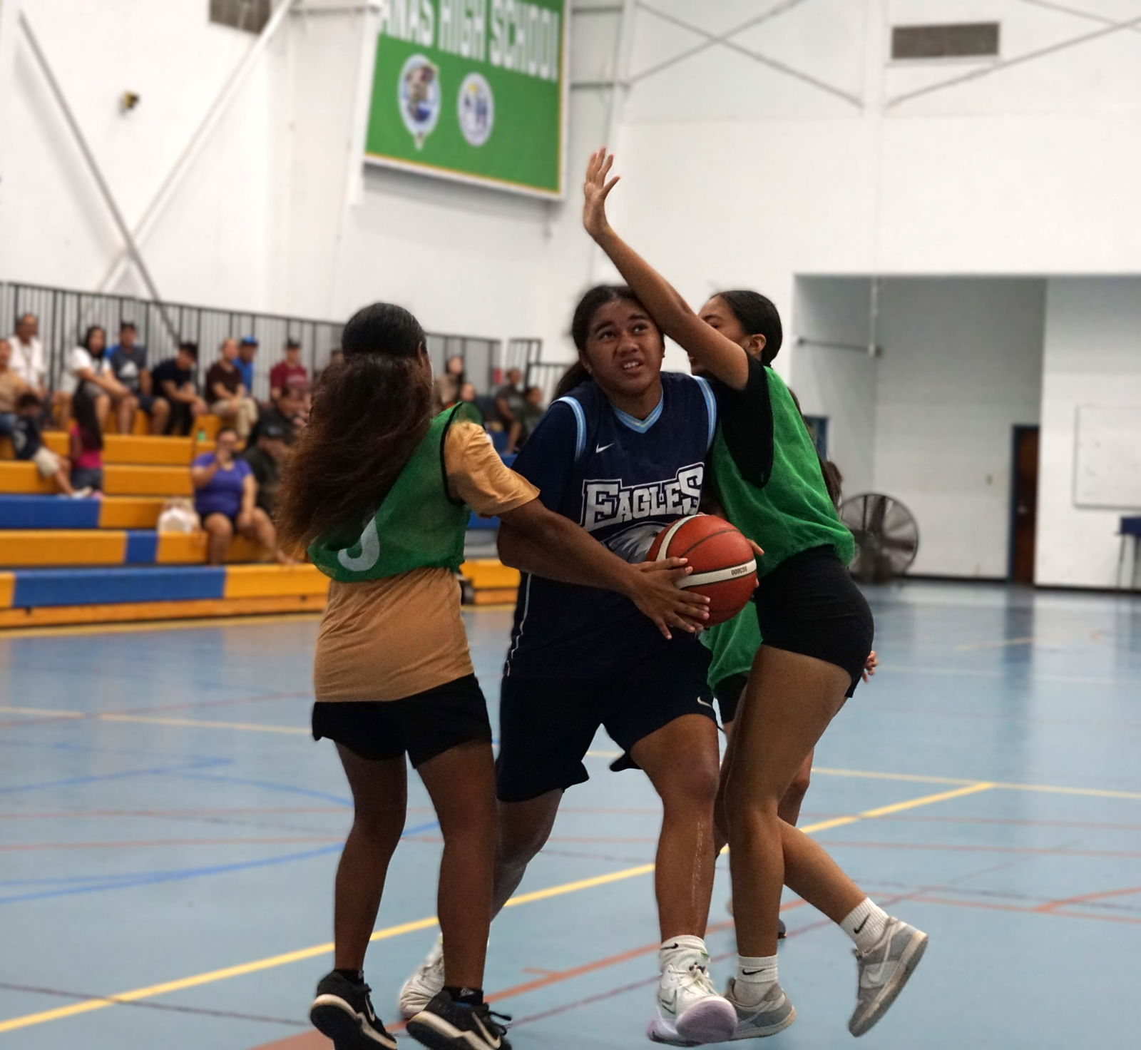 Grace Christian School's Aaleyoh Fatialofa drives through two Dandan Middle School defenders during the girls middle school division championship game of the IT&E Interscholastic Basketball League SY23-24 at the MHS gym on Saturday.