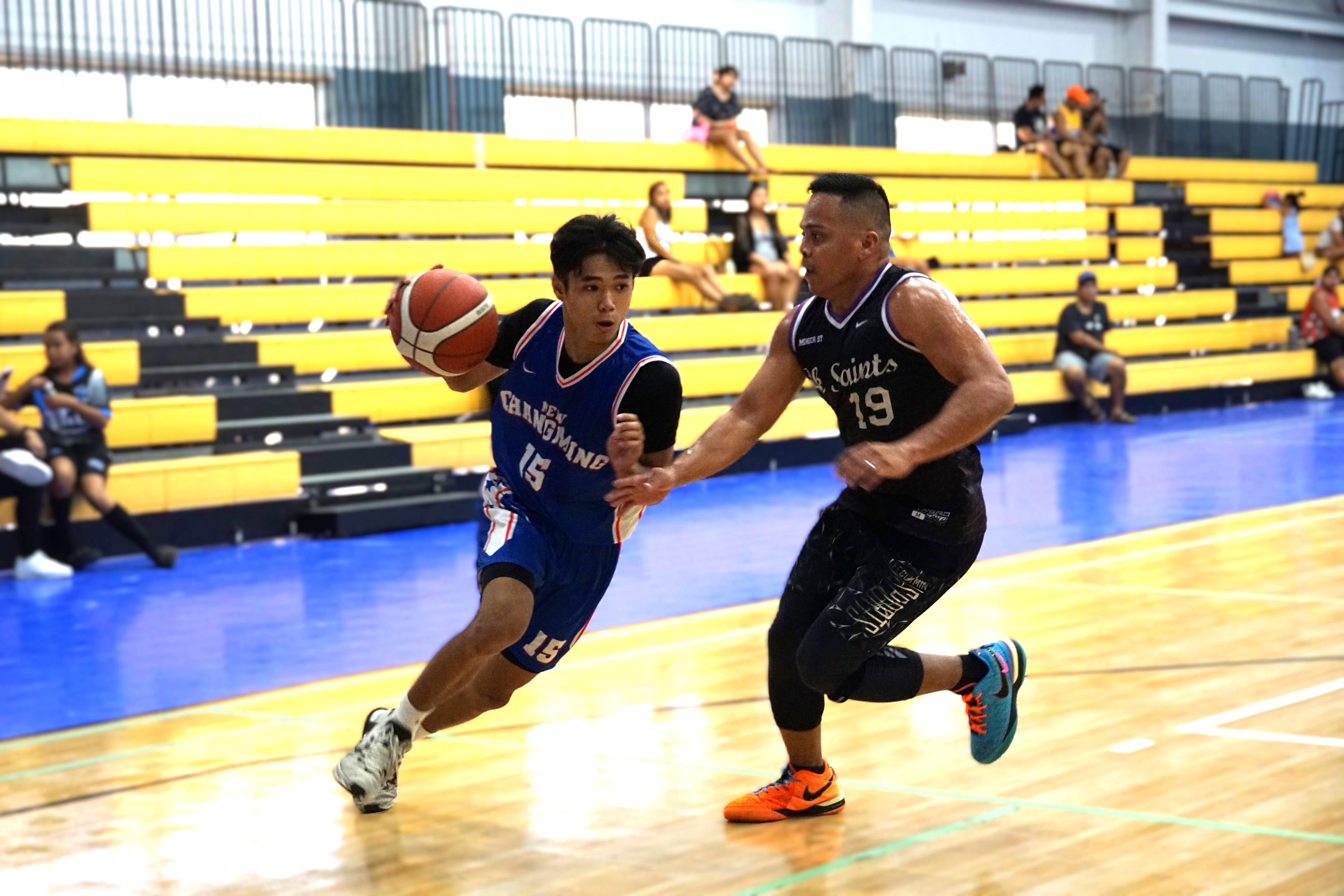 New Changming's Christian David attempts to drive past the Saints' Leo Galarse during a Michelob Ultra Cup 2024 game at the Ada gym on Saturday.