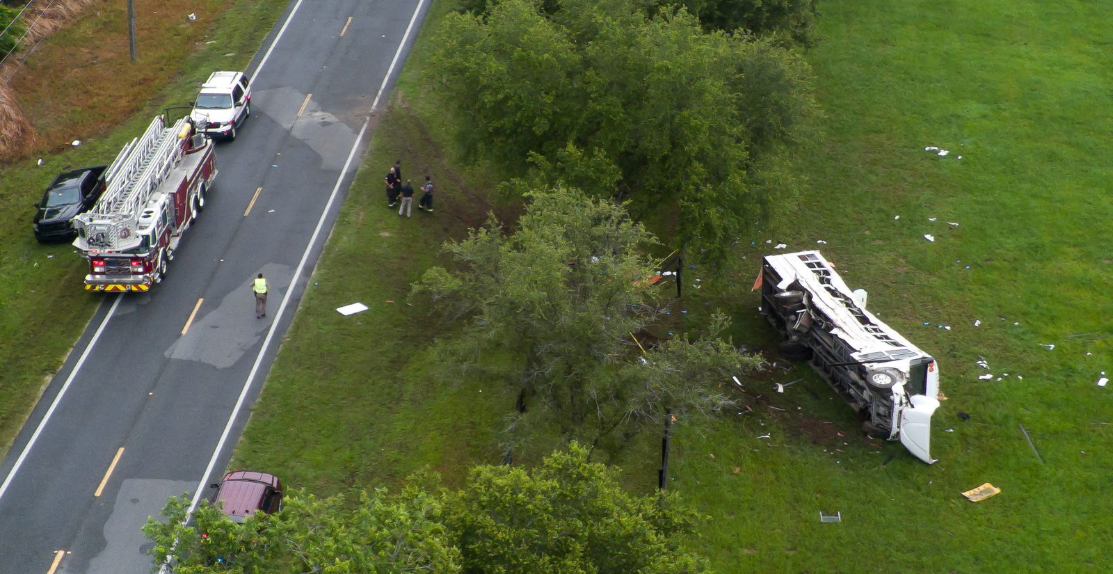 Emergency services attend the scene after a bus carrying laborers to a melon farm overturned in a fatal crash near Dunnellon, Florida, May 14, 2024.