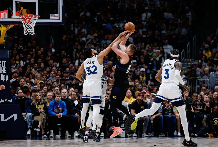 Denver Nuggets center Nikola Jokic (15) attempts a shot as Minnesota Timberwolves center Karl-Anthony Towns (32) defends in the first quarter during game two of the second round for the 2024 NBA playoffs at Ball Arena in Denver, Colorado, May 6, 2024.