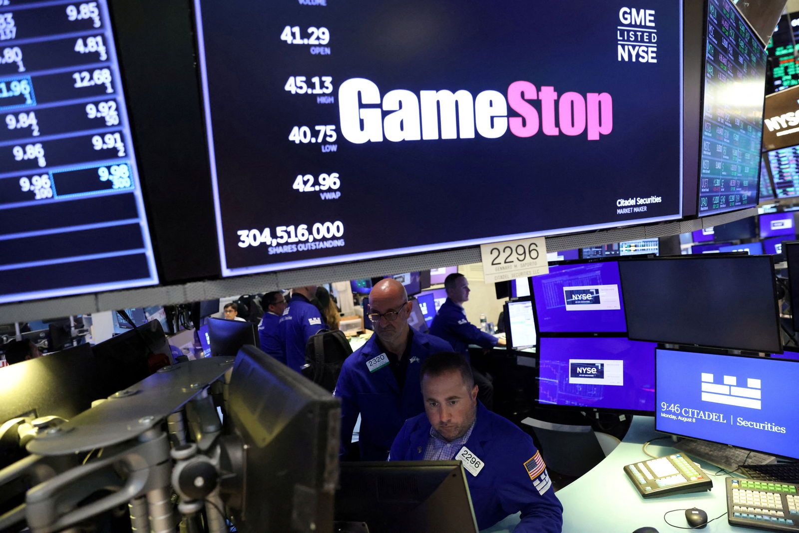 Traders work under signage for GameStop Corp. on the trading floor at the New York Stock Exchange in Manhattan, New York City, Aug. 8, 2022.
