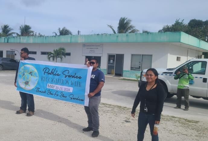 CUC Rota employees proudly hold  their banner during the roadside waving activity.