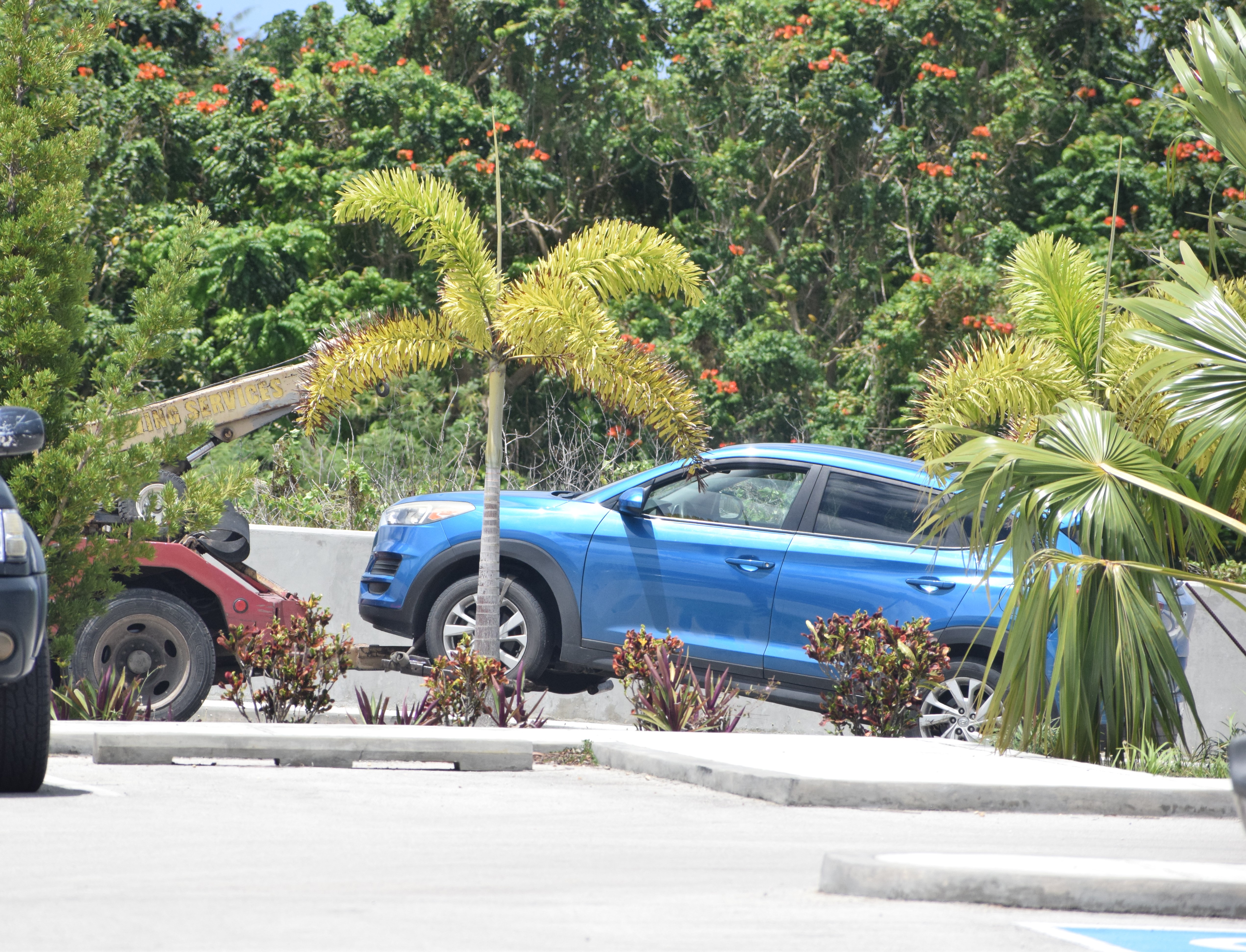 Sammy Kapileo's blue Hyundai Tucson is towed from the parking lot of Unites States Courthouse in Gualo Rai on Thursday.