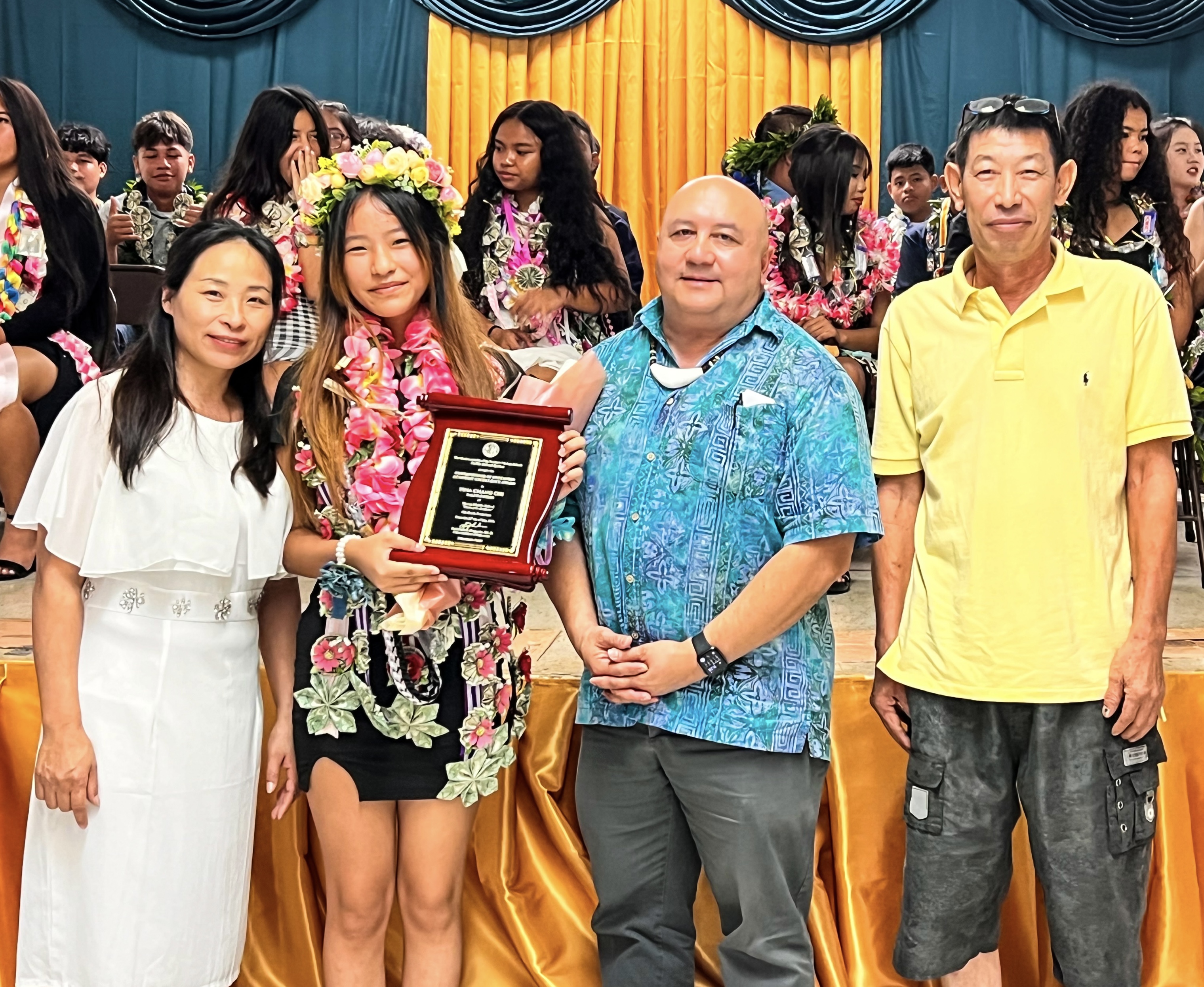 The Commissioner of Education Academic Excellence Award was presented to the class salutatorian, Tina Chang Chi, by Commissioner of Education Dr. Lawrence F. Camacho. Also in photo are Chi’s parents.
