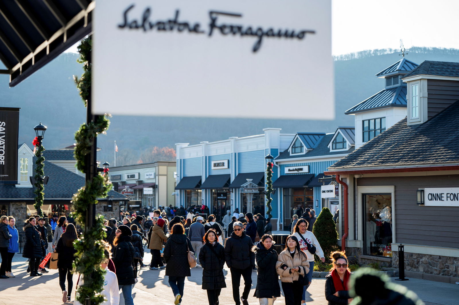 Shoppers walk to stores as retailers compete to attract shoppers and try to maintain margins on Black Friday, one of the busiest shopping days of the year, at Woodbury Common Premium Outlets in Central Valley, New York, Nov. 24, 2023.