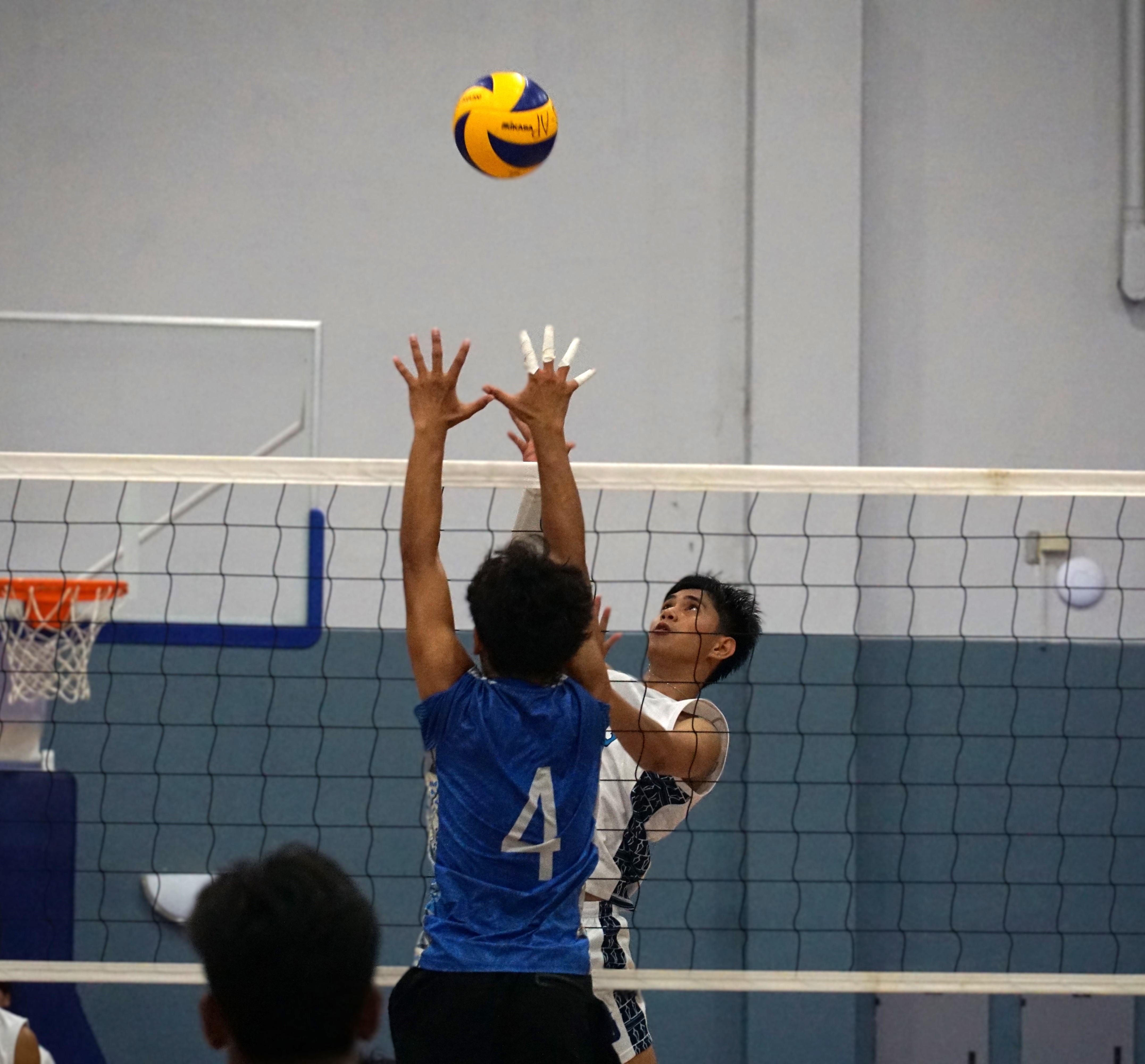 MHS team captain Jerome Manzon reaches for the spike over a SIS defender during the boys high school division championship game of the NMIVA-PSS Interscholastic Volleyball League SY23-24 at the Ada gym on Saturday.