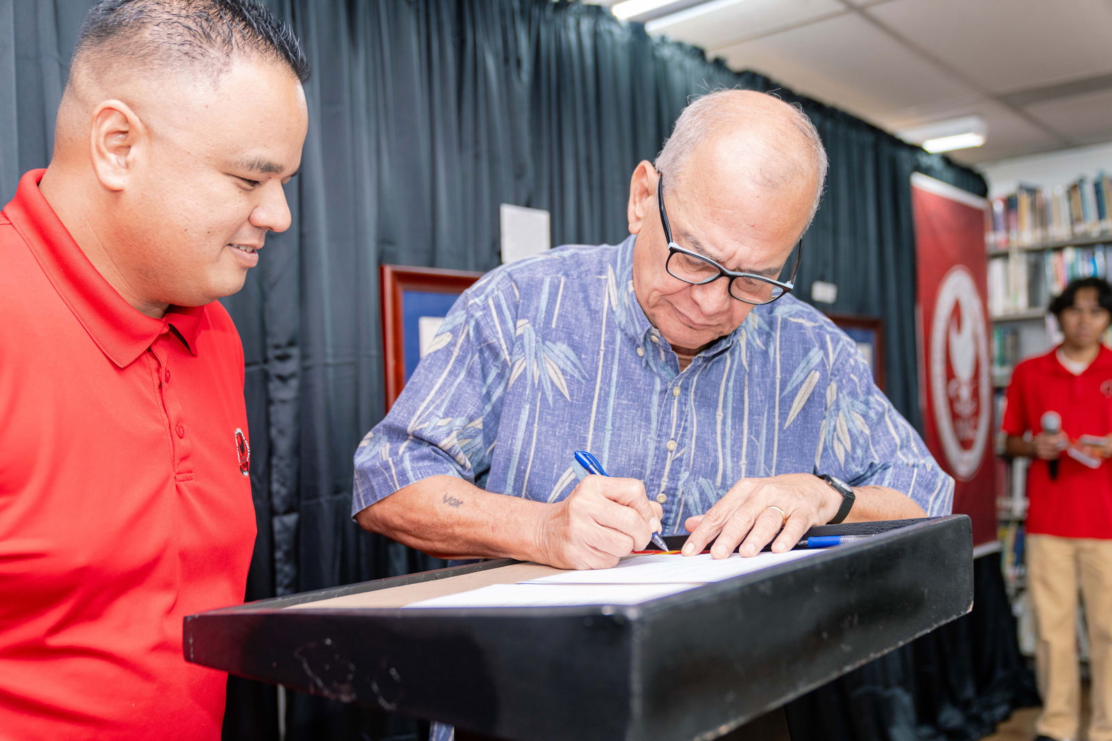 U.S. Congressman Gregorio Kilili Camacho Sablan, center, signs the official deed of gift transferring the ownership of Sablan's documents, records, and other artifacts to the Northern Marianas College. Also in photo is CNMI Archivist Ray Muna.